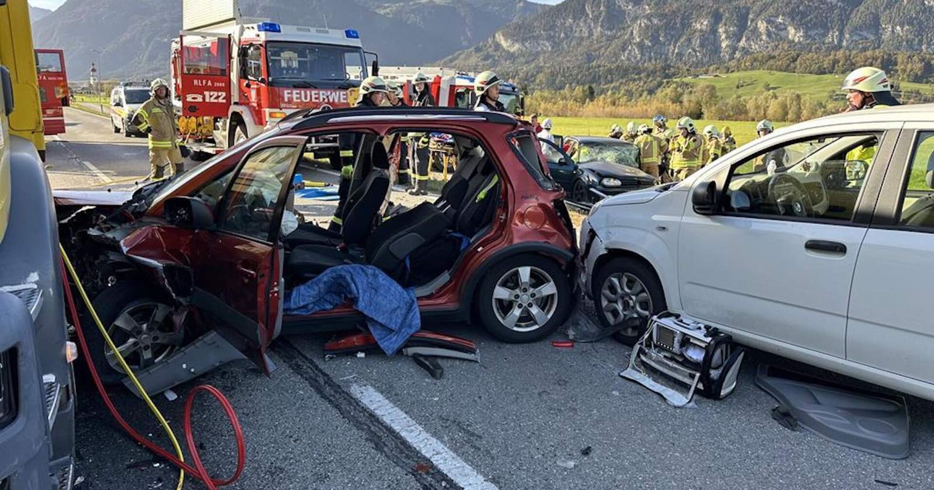 Einsatzkräfte und zerstörte Autos an der Unfallstelle in Radfeld.