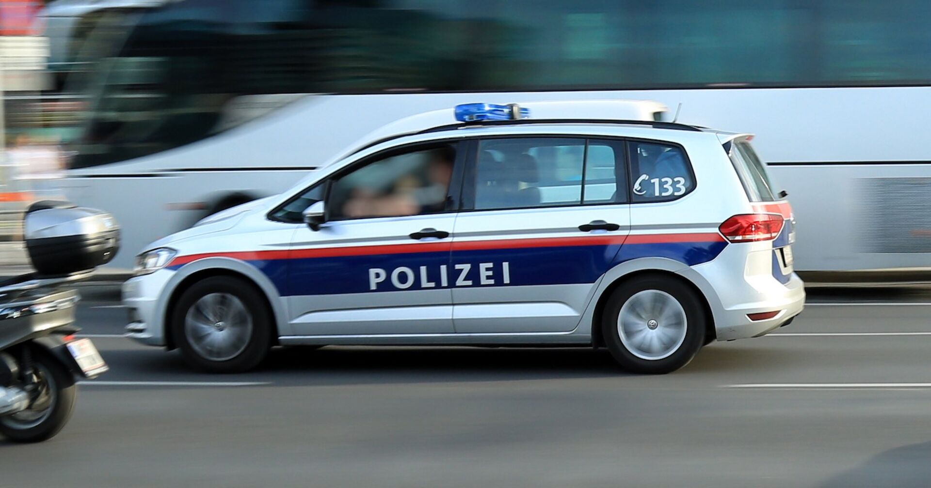 Ein Polizeiauto fährt auf einen stark befahrenen Straße zu einem Einsatz.