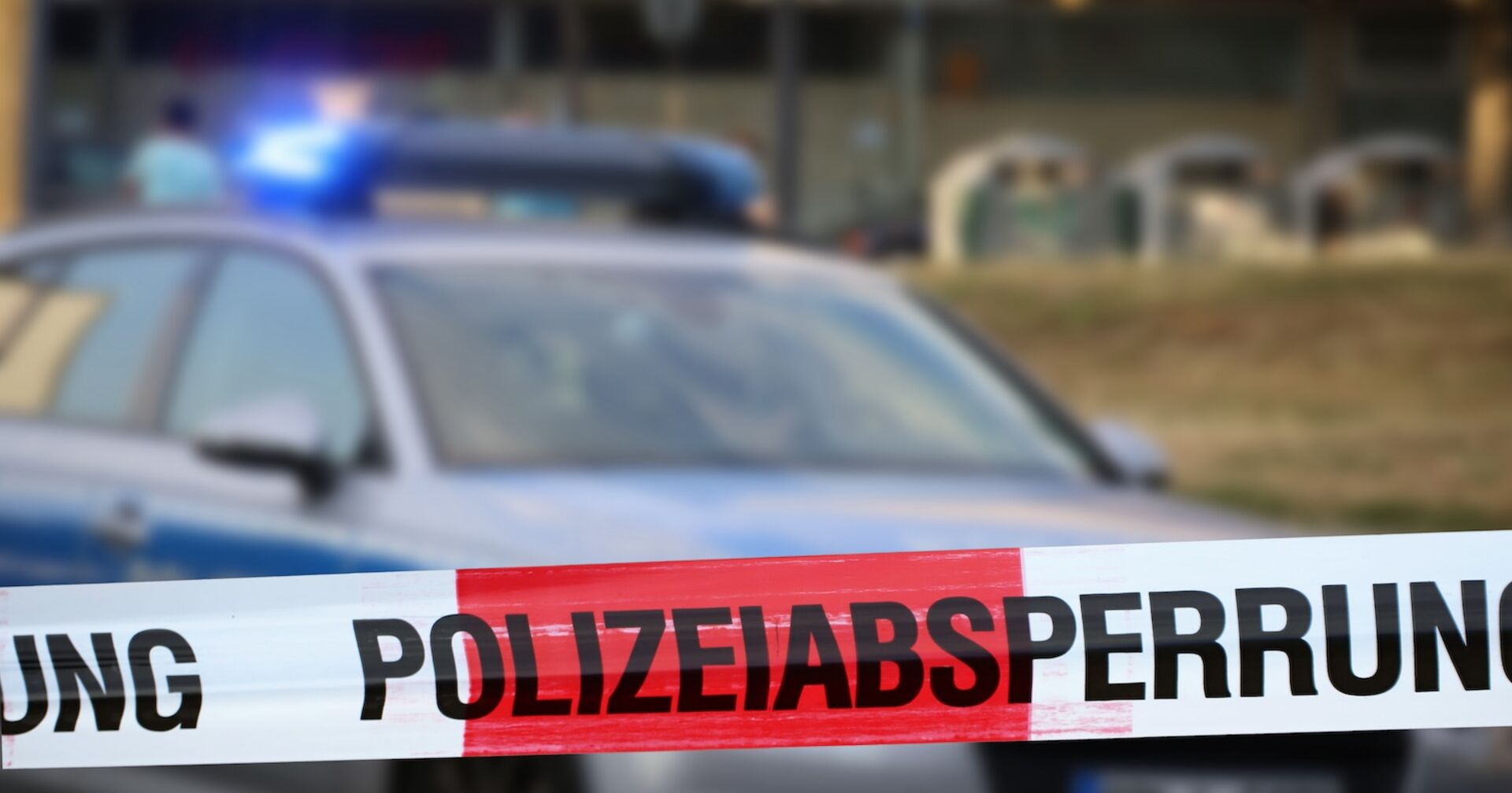 Polizeiauto und Absperrung an einem Einsatzort.