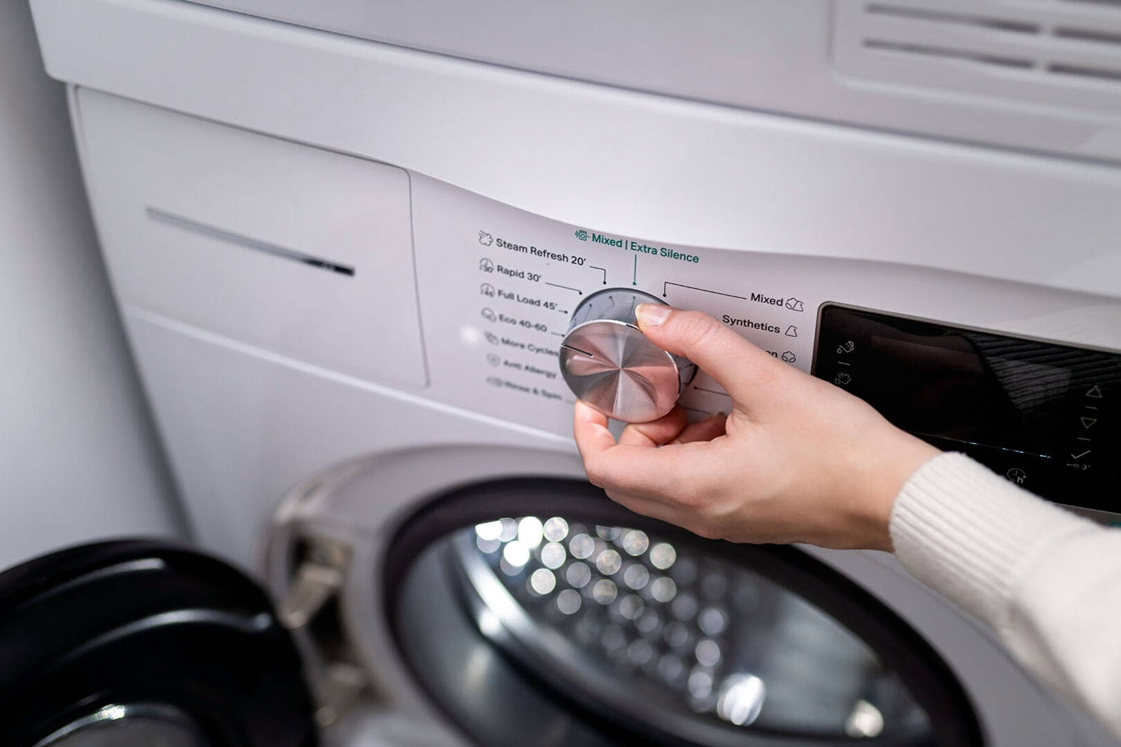 Frau bedient Waschmaschine | Credit: iStock.com/Damian Lugowski