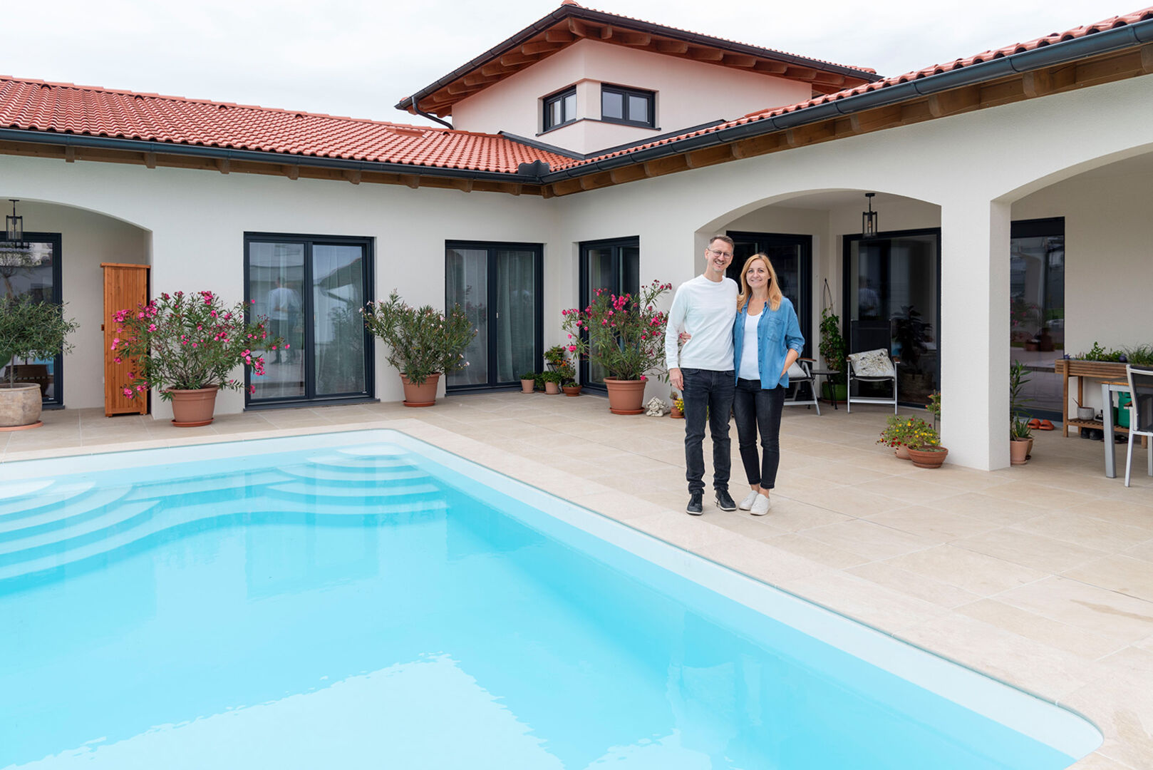 Junges Ehepaar vor ihrem Wohnhaus mit Pool | Credit: HARTL HAUS