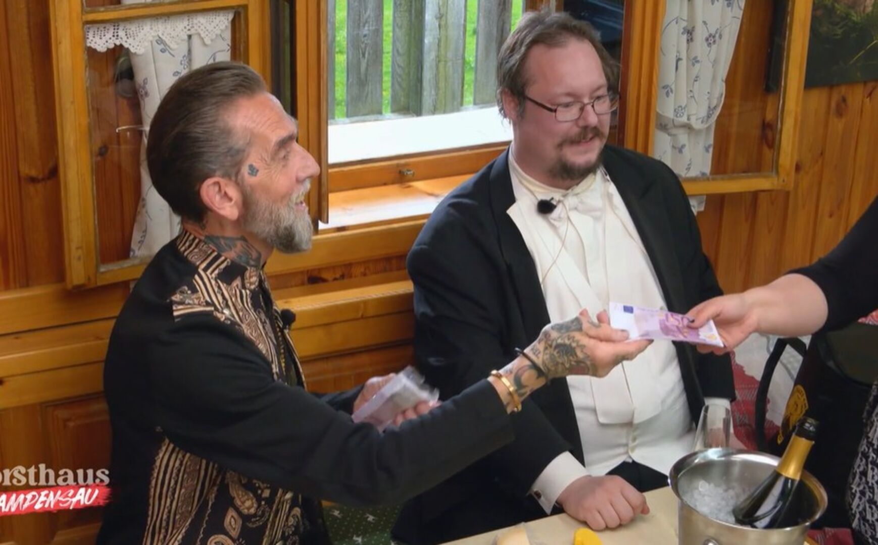 Käse-Millionär Roland und sein Butler verteilen Geldscheine.