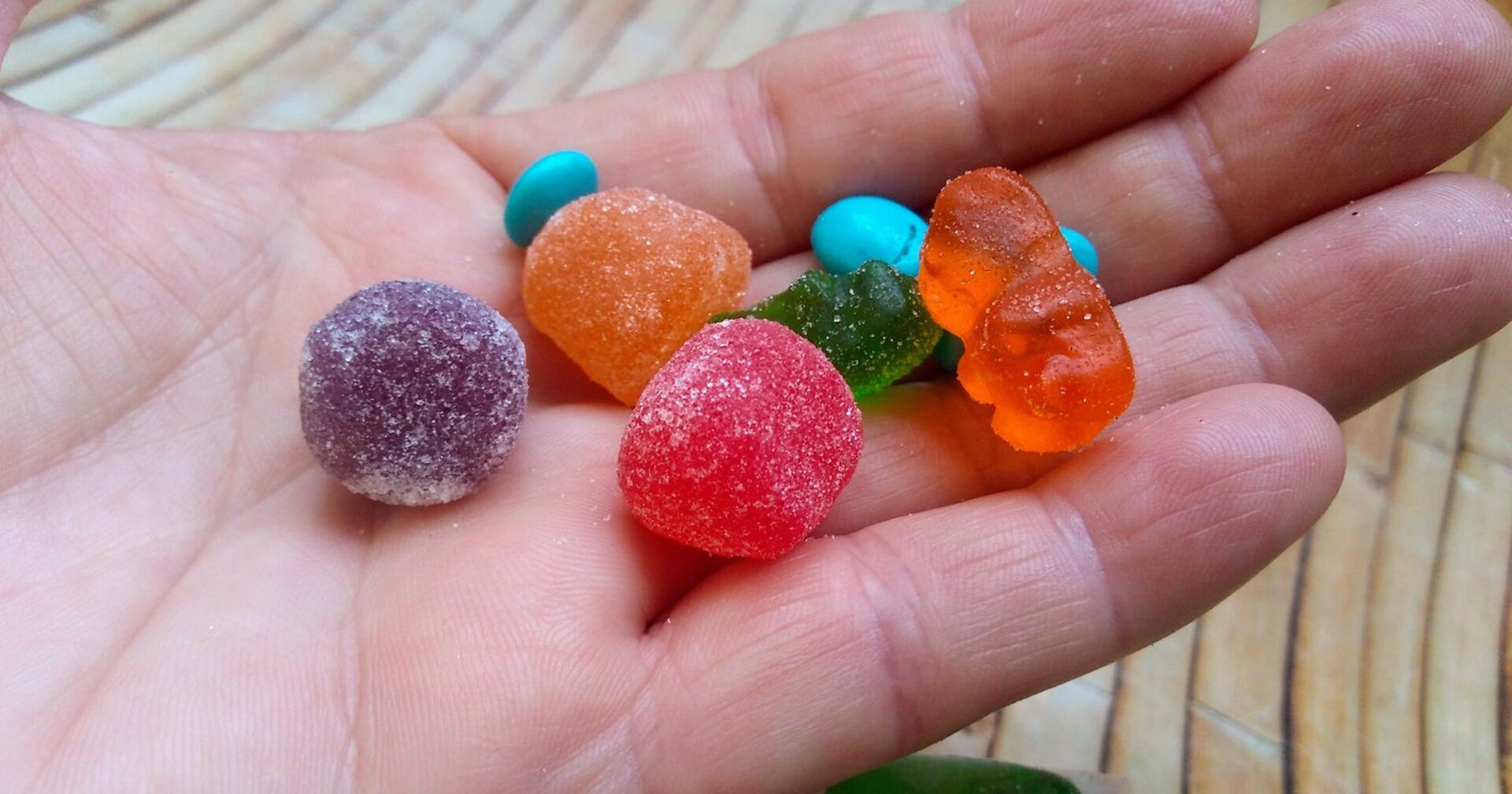 In einer Hand liegen verschiedenen Fruchtgummis.