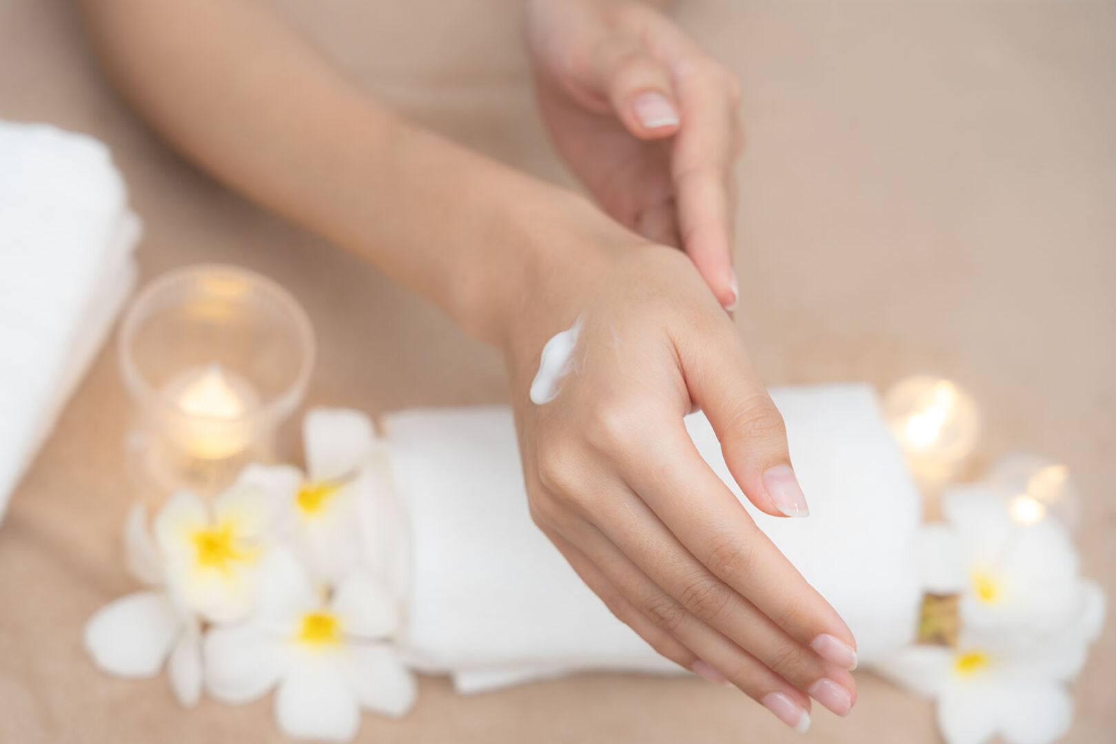 Frau cremt sich Hände ein | Credit: iStock.com/Nuttawan Jayawan