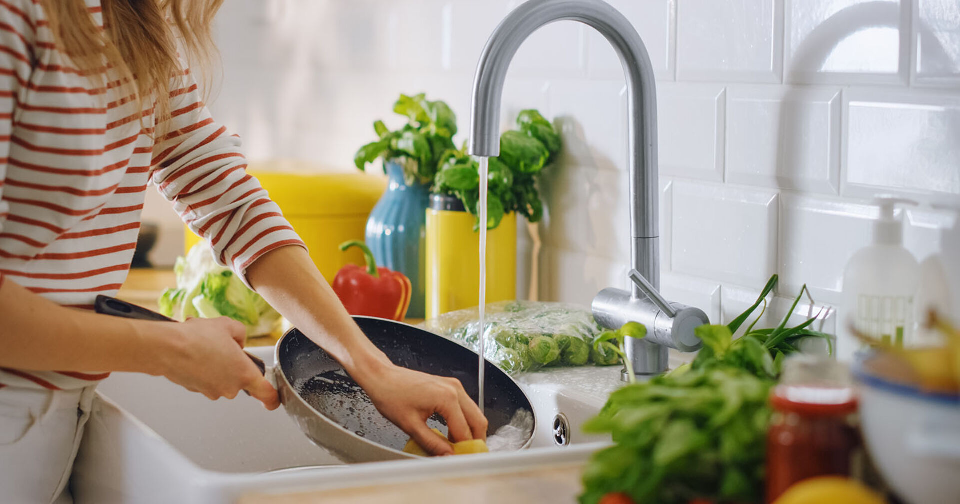 Frau reinigt Pfanne | Credit: iStock.com/gorodenkoff