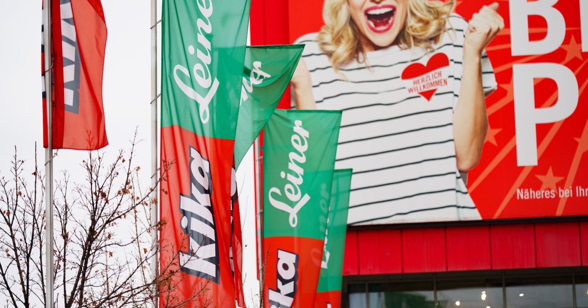 Kika- und Leiner-Flaggen vor einem Möbelhaus.