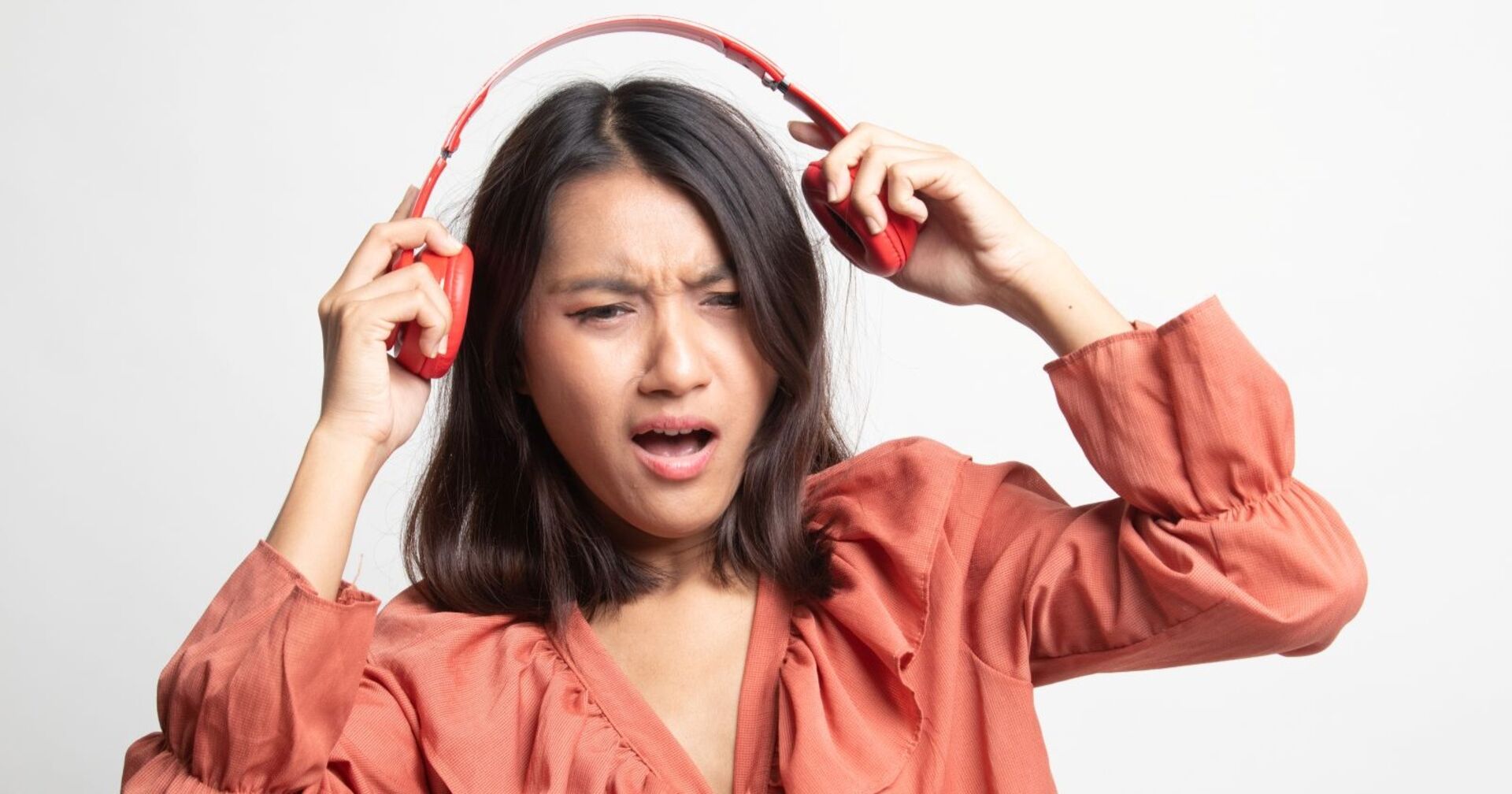 Frau setzt sich Kopfhörer ab und schaut irritiert