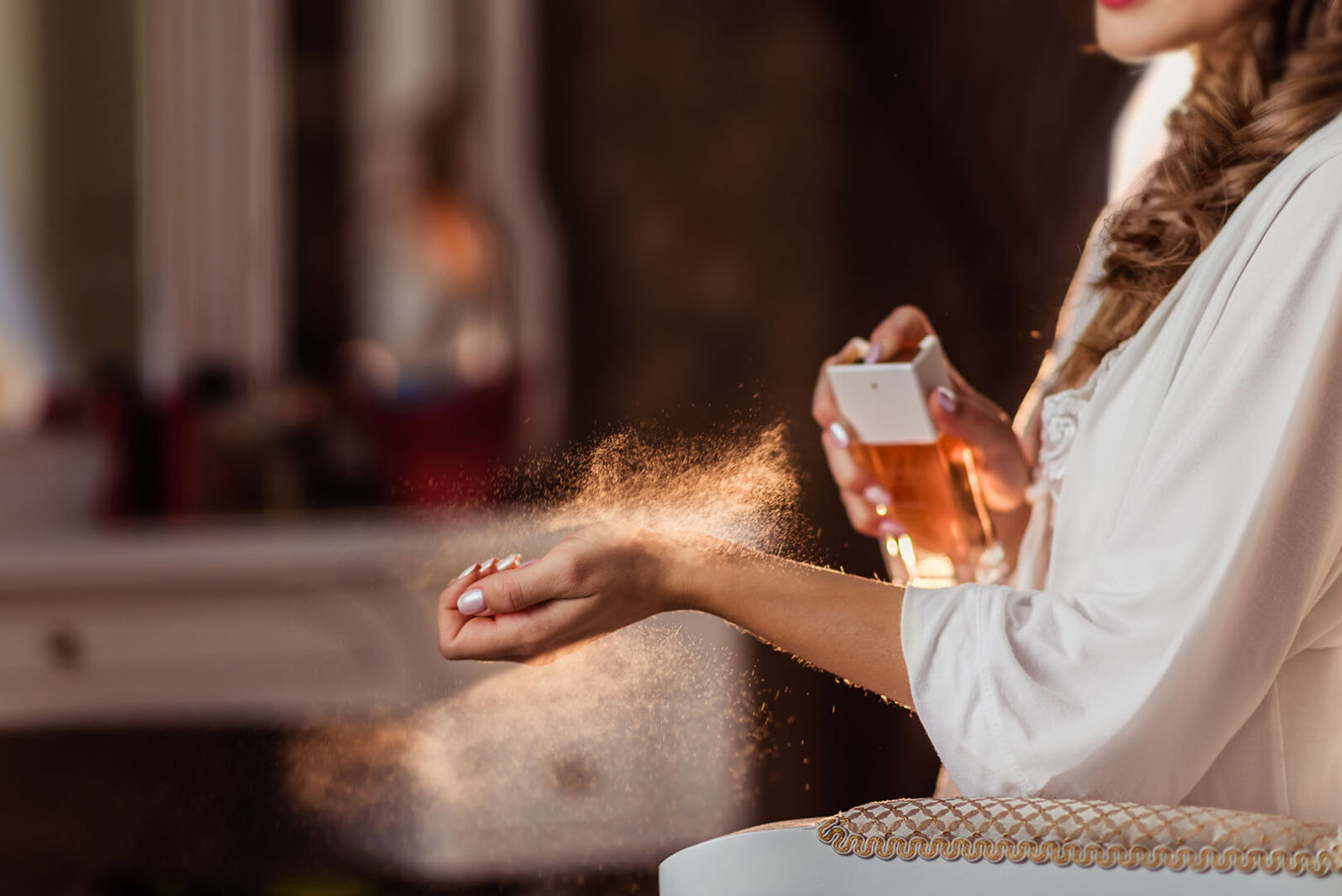 Frau sprüht Parfum auf Handgelenk | Credit: iStock.com/Galina Tsyrulnik
