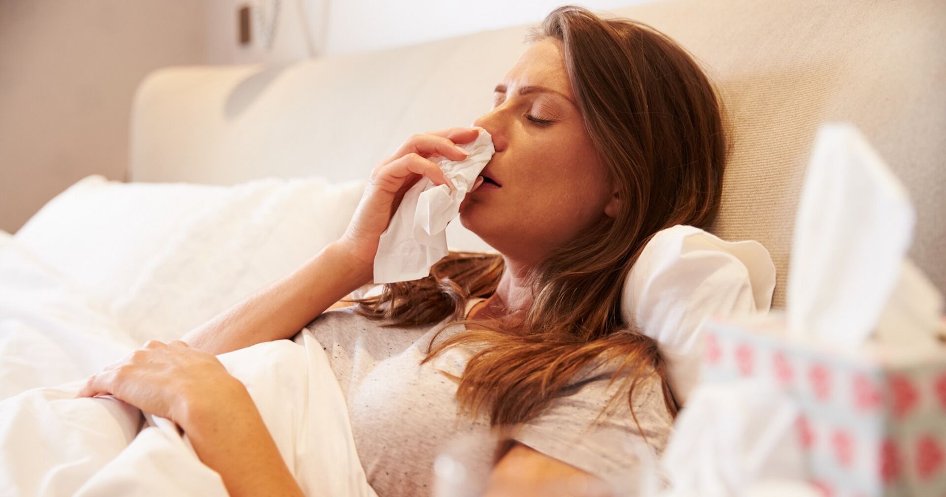 Eine Frau liegt krank im Bett.