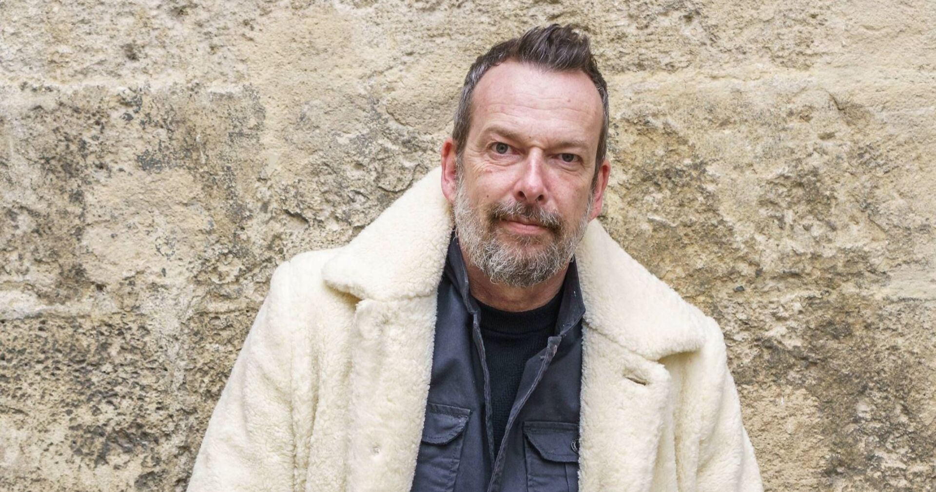 Robert Kratky lehnt gegen eine Mauer