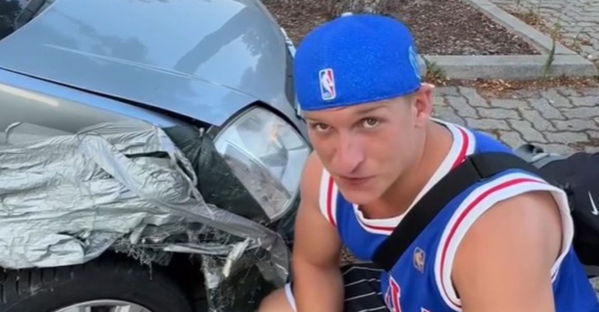 Satans Bratan posiert neben einem Auto.