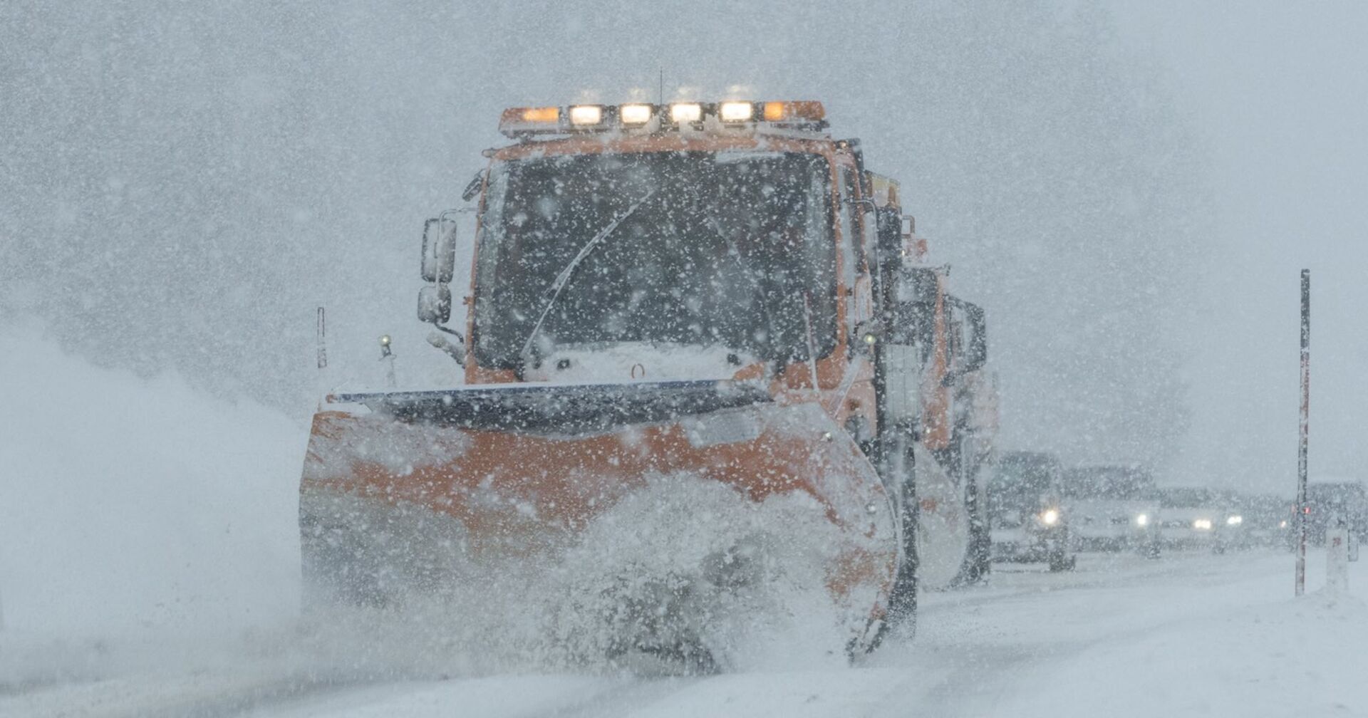 Ein Schneepflug auf einer Landstraße.