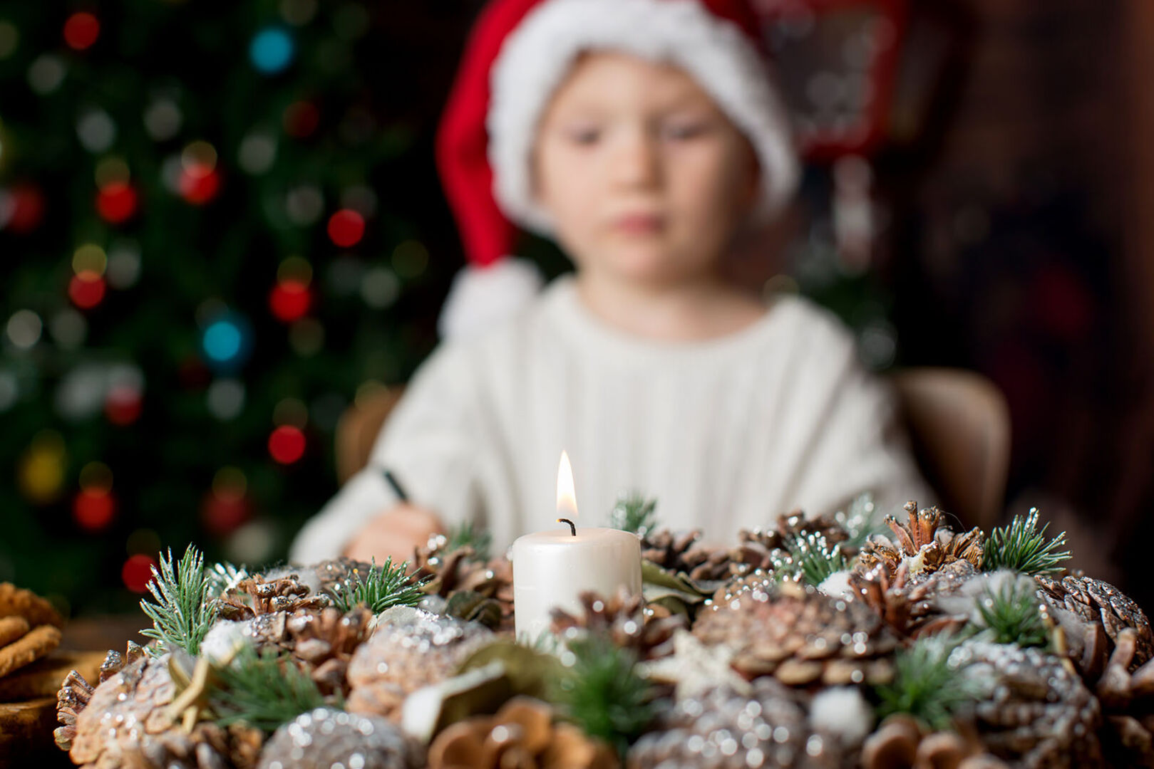 Kind steht vor Adventskranz | Credit: iStock.com/tatyana_tomsickova
