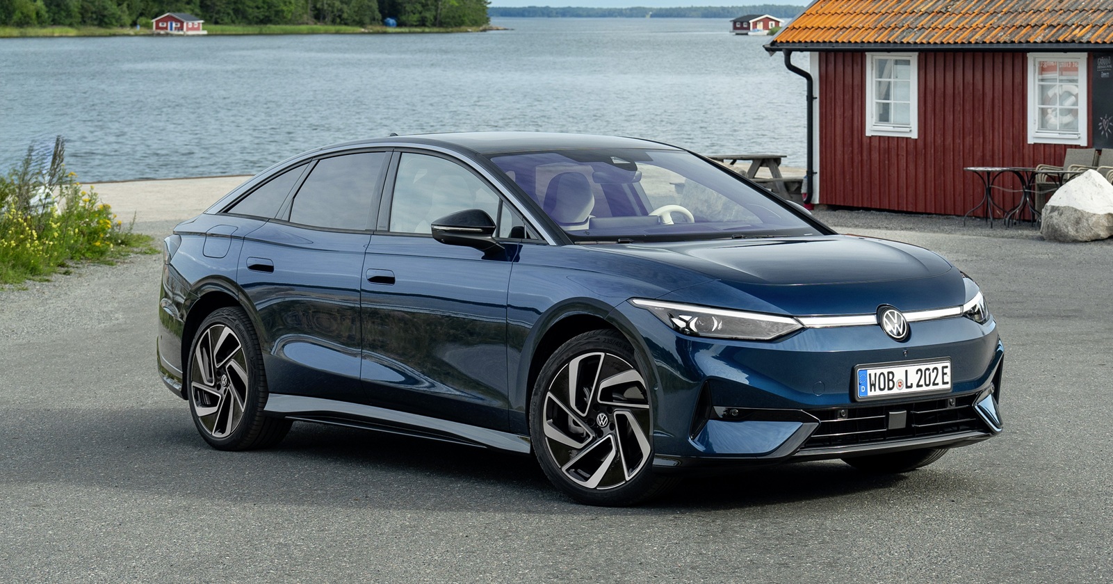 Der VW ID.7 vor einem Landhaus an einem See