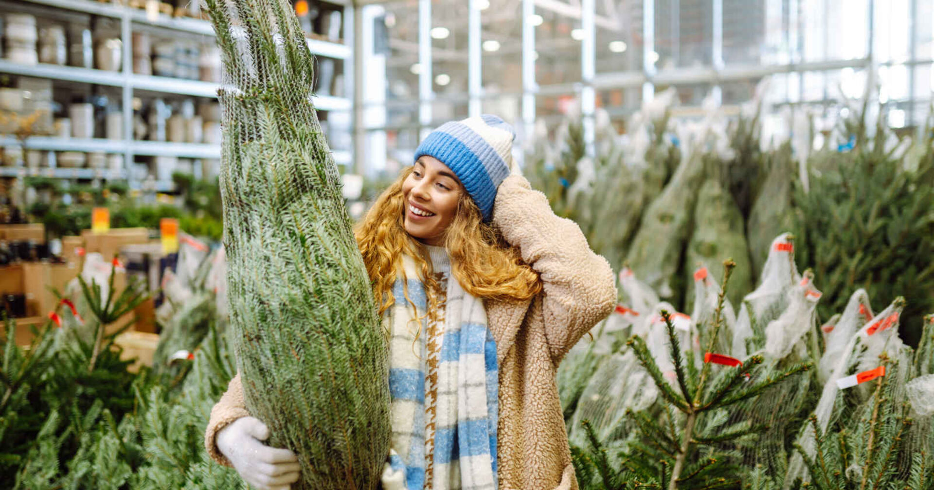 Eine Frau kauft einen Christbaum