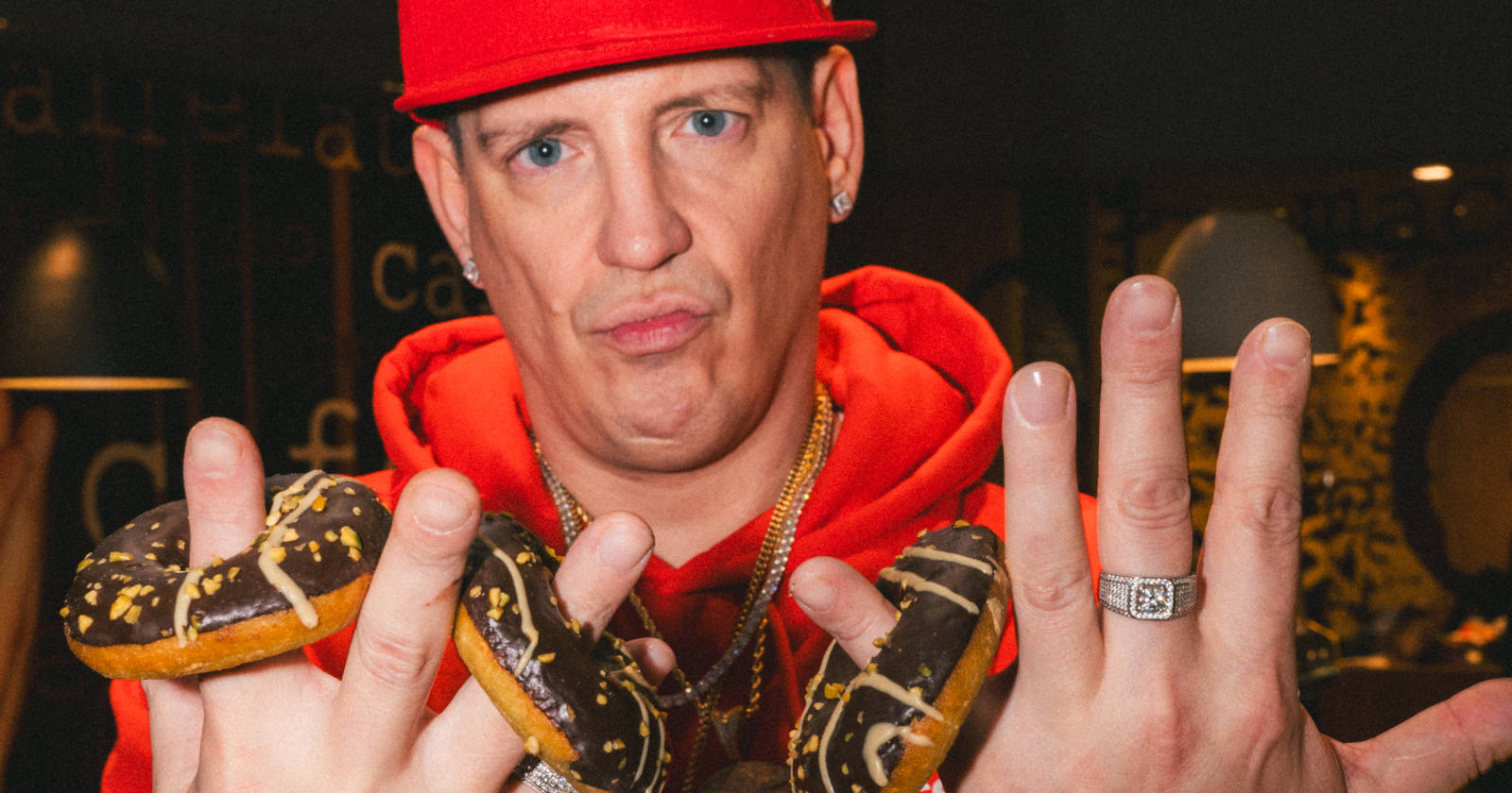 Mann in rotem Pulli hält Donuts auf den Händen