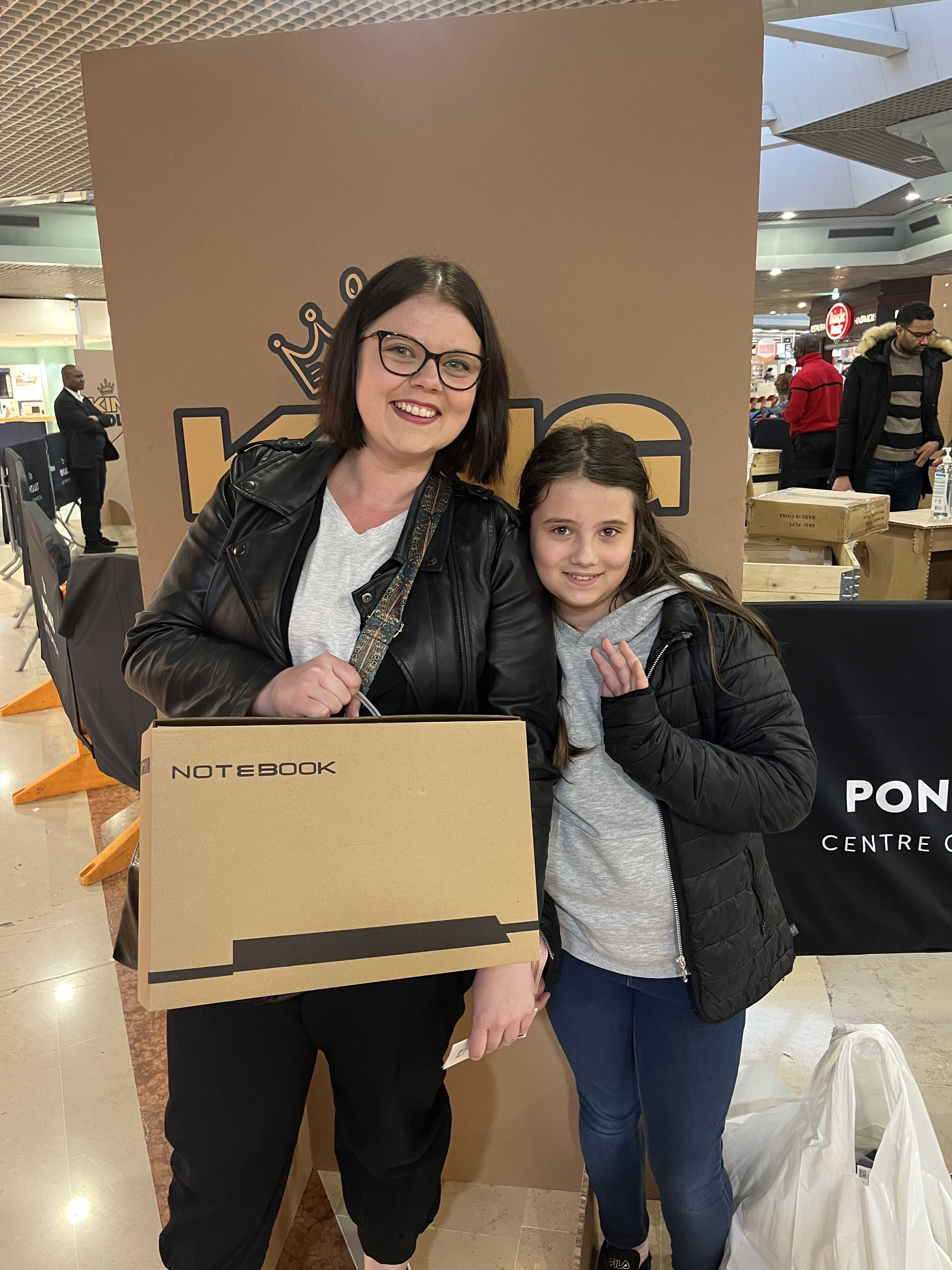 Eine glückliche Mutter mit ihrer Tochter und einem Notebook in der Hand