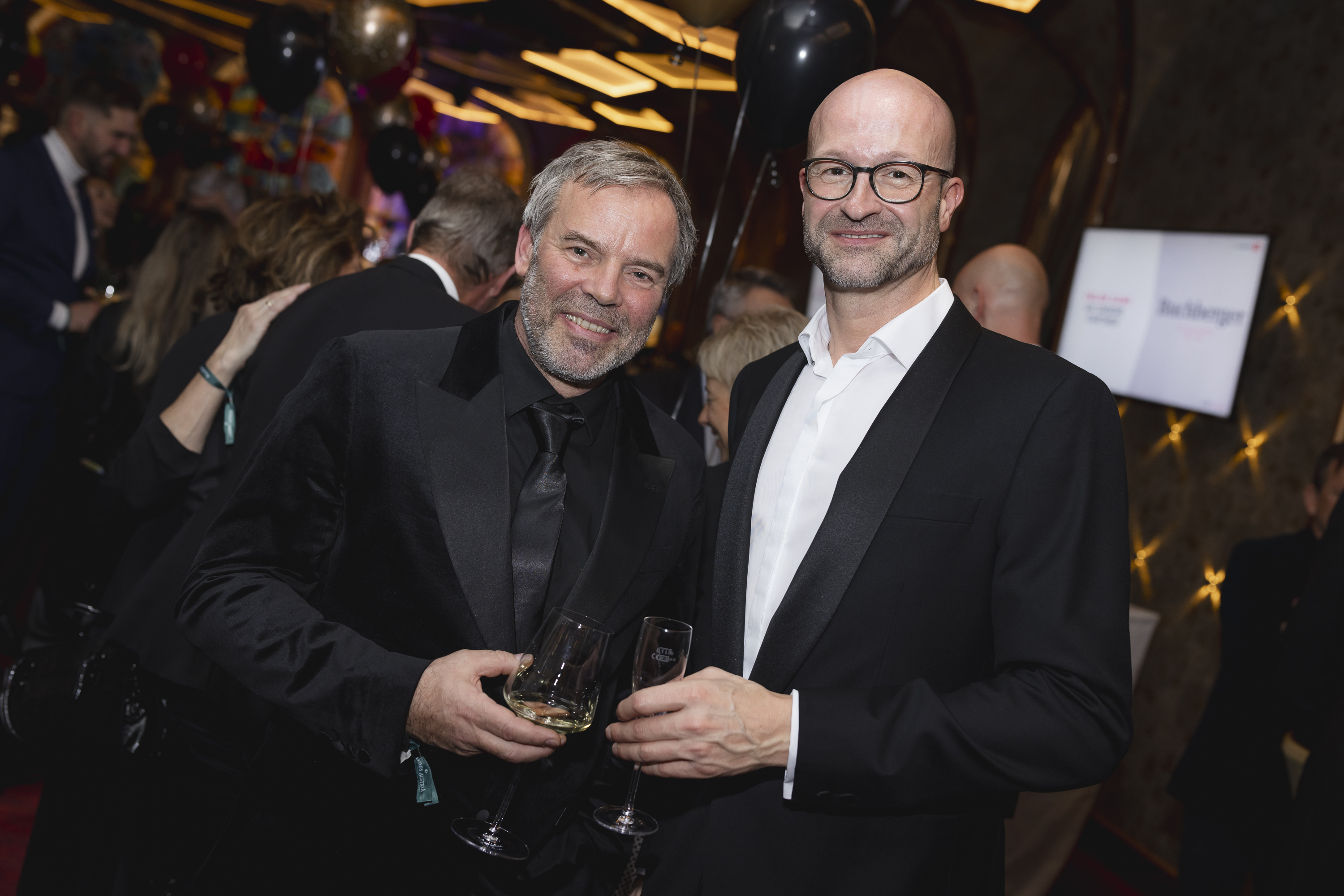 Zwei Männer in Anzügen stehen nebeneinander