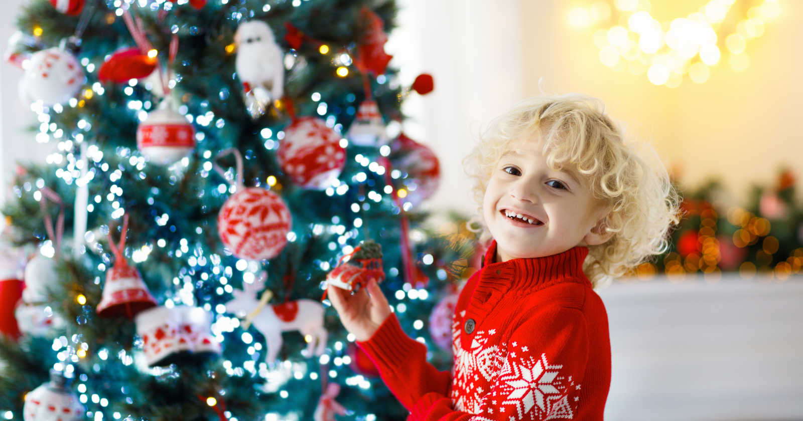 Ein Kind ist glücklich vor einem Weihnachtsbaum