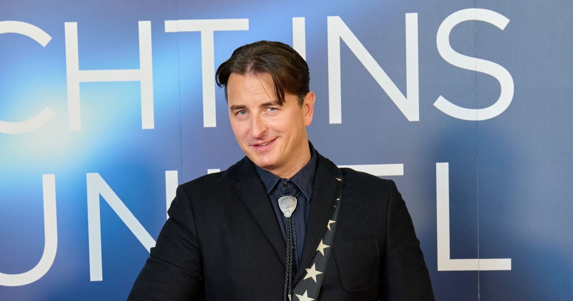 Andreas Gabalier lächelt in die Kamera.