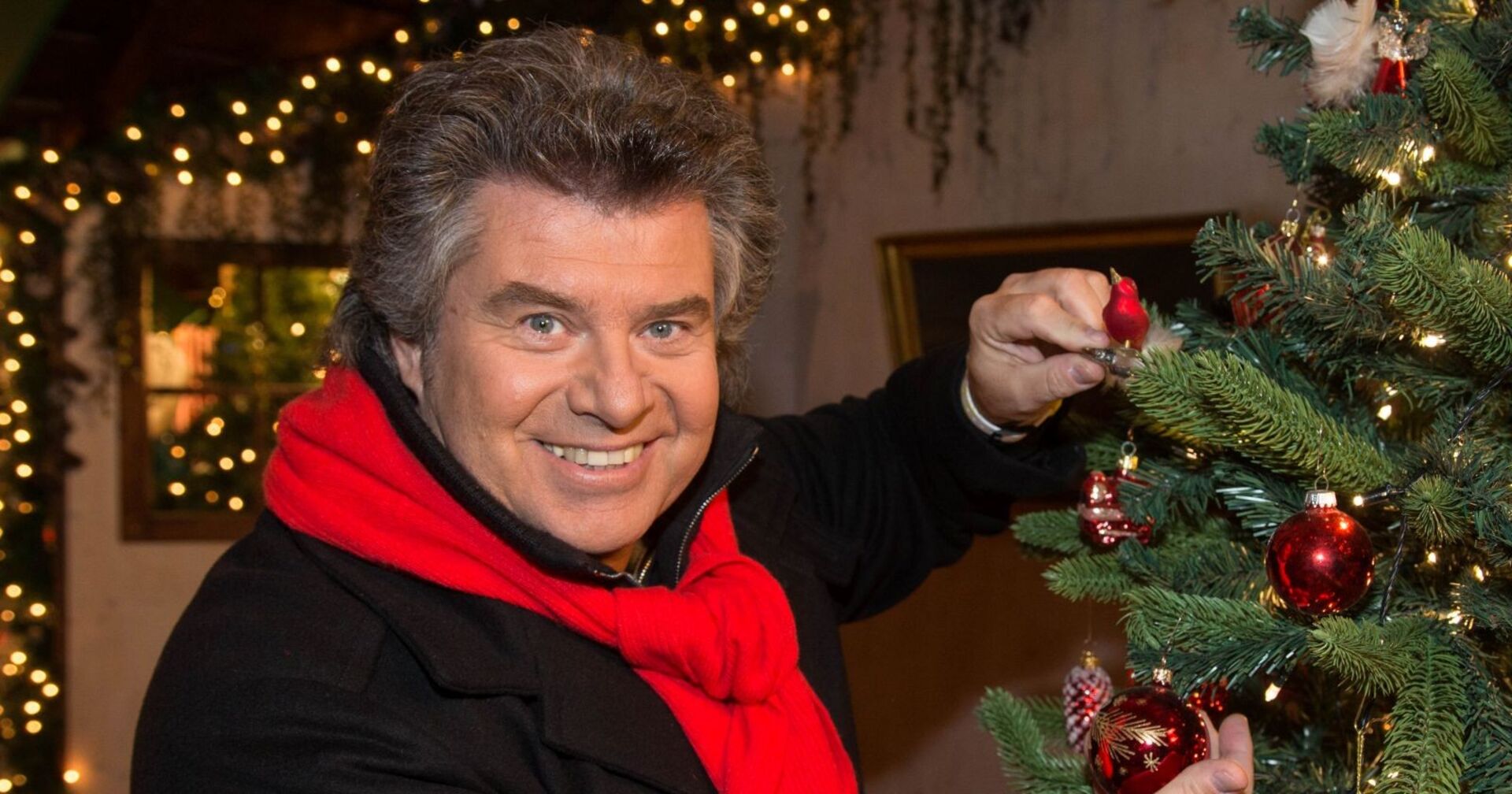 Andy Borg schmückt einen Weihnachtsbaum