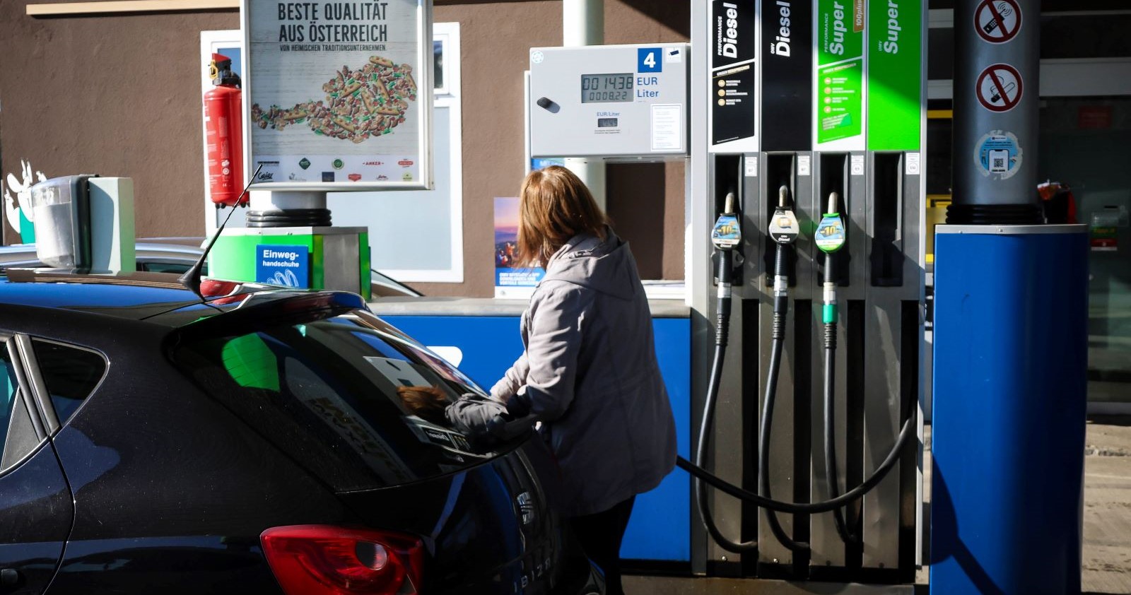 Eine Frau tankt ihr Auto an einer Tankstelle voll.