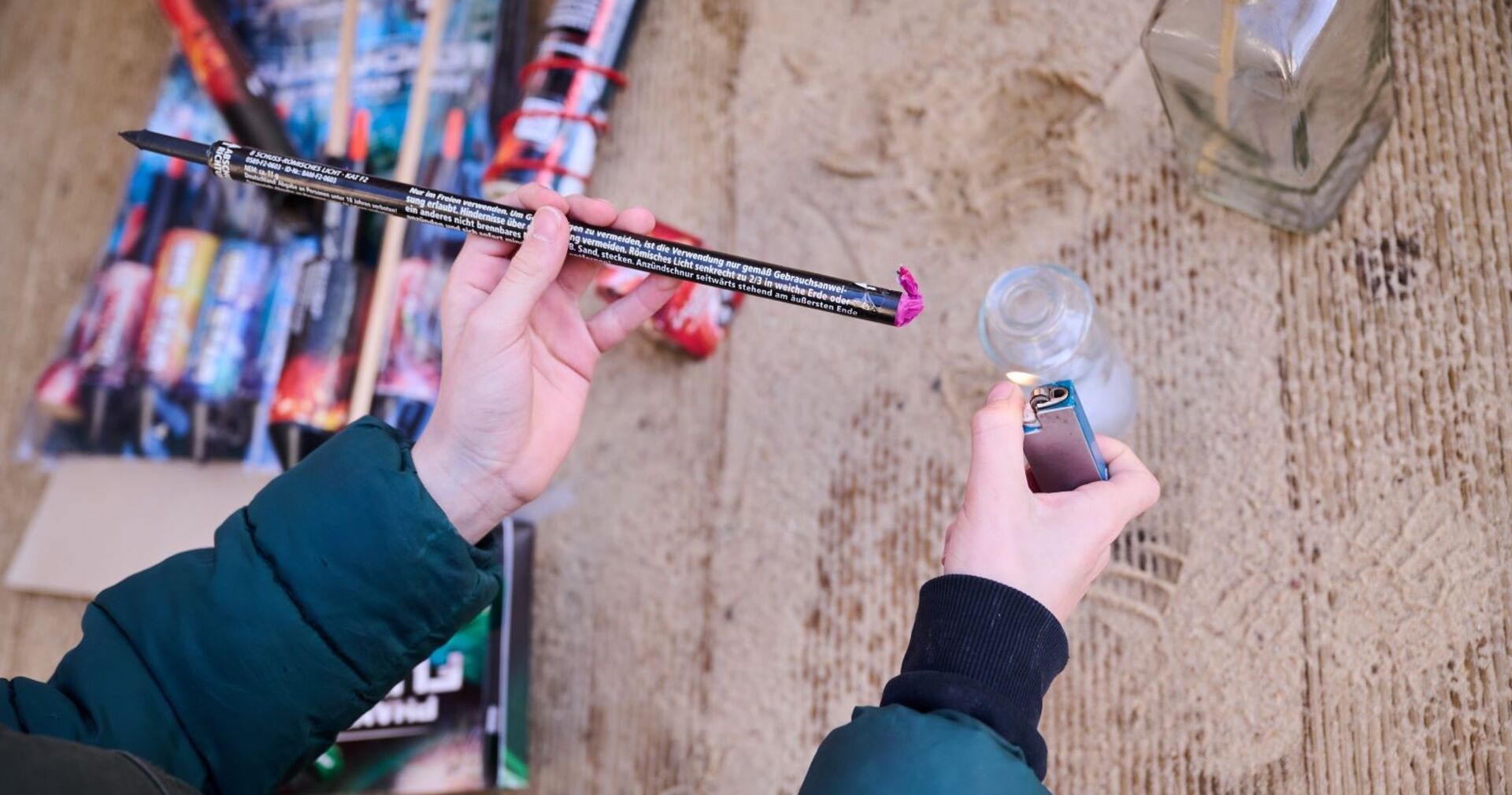 Ein Jugendlicher hantiert mit einem Böller und einem Feuerzeug.