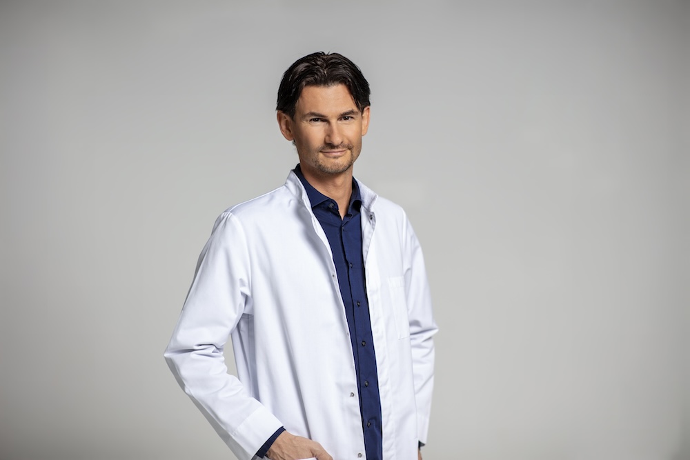 Foto des Genforschers Daniel Wallerstorfer, der unter anderem zur Wirkung von Omega-3-Fettsäuren forscht, in einem Arztkittel