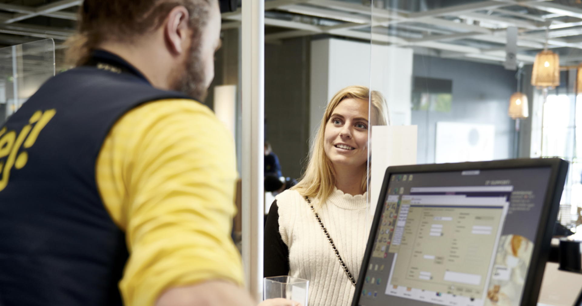 eine Frau informiert sich bei einem Ikea-Mitarbeiter