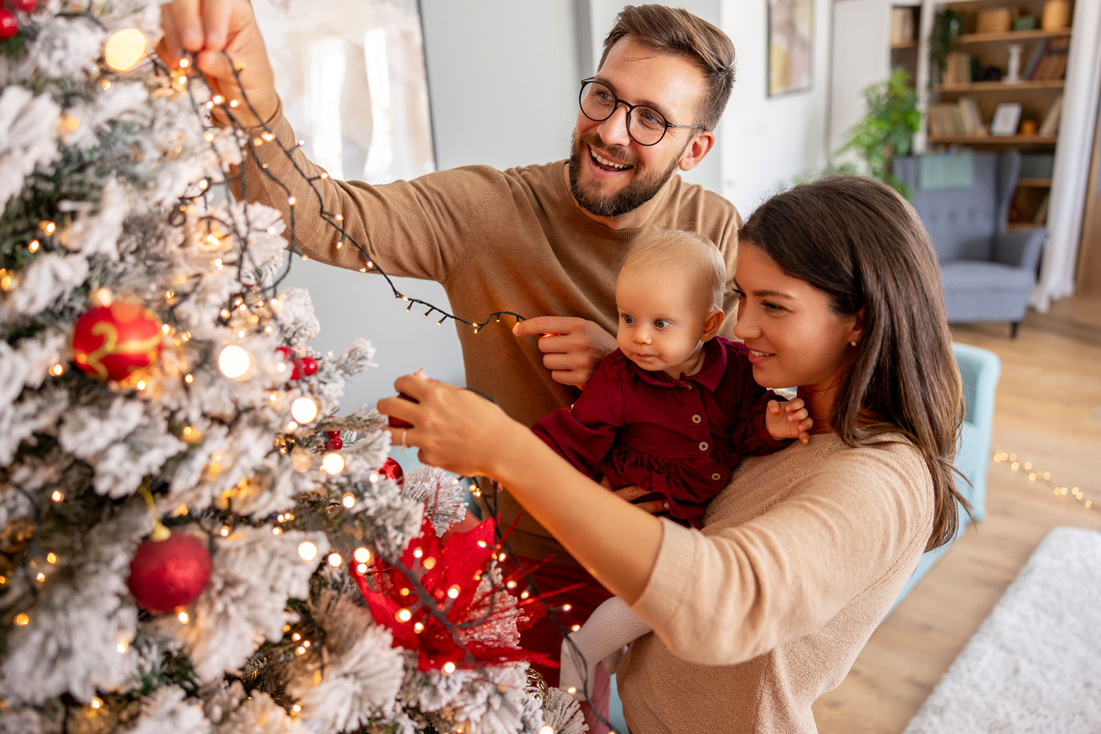 Familie schmückt Weihnachtsbaum | Credit: iStock.com/vladans