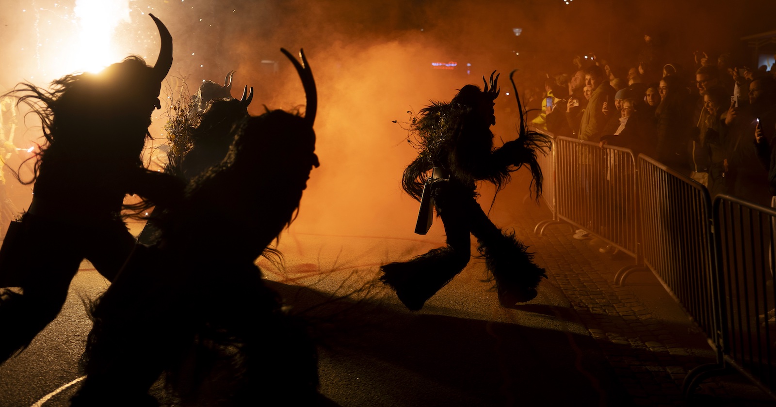 Drei Krampusse stürmen auf Besucher zu.