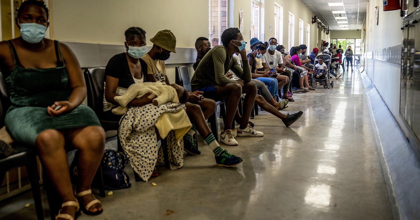 Menschen warten in Afrika im Spital auf einen Arzt.