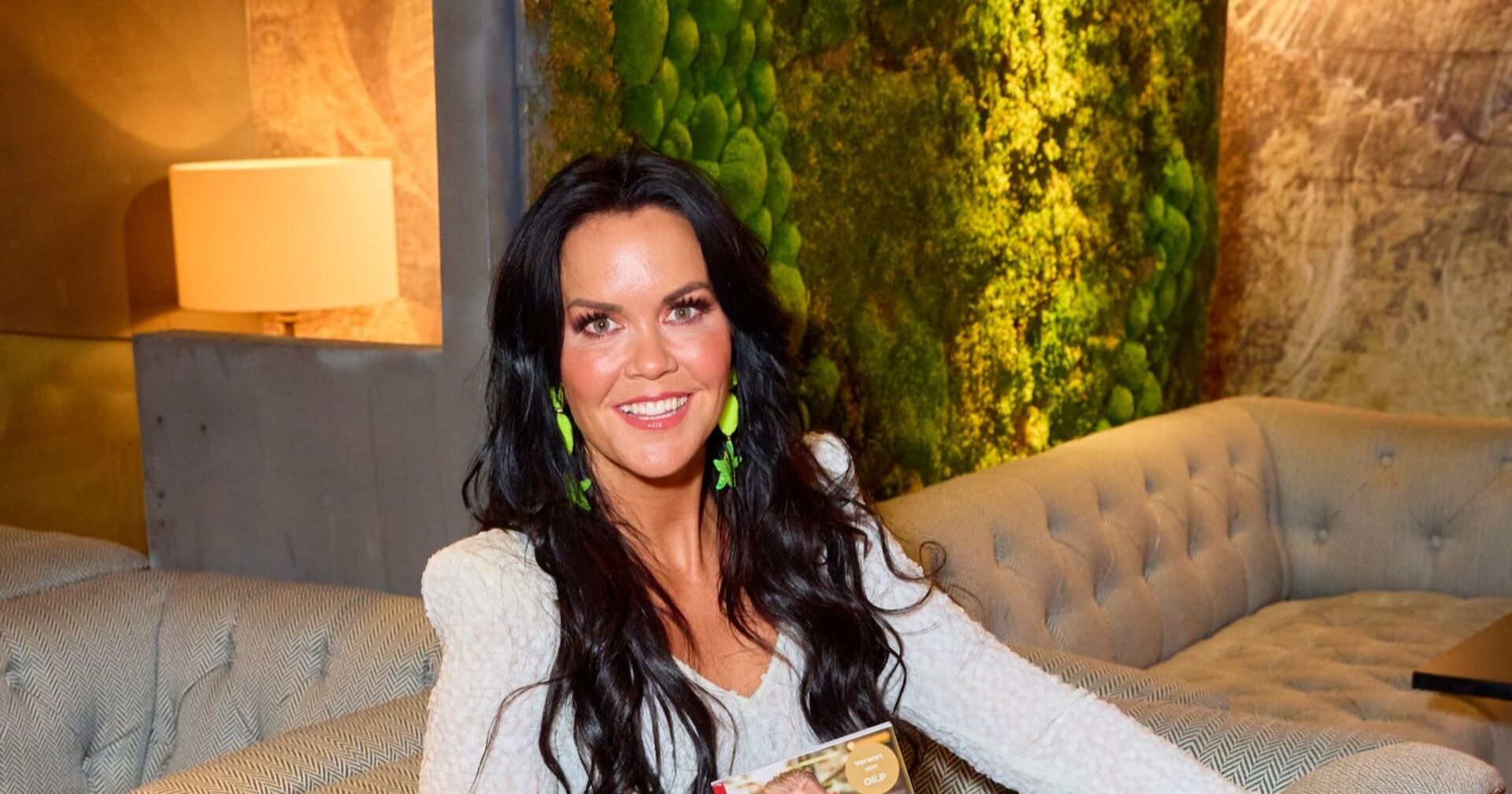 Martina Reuter sitzt lächeln auf einer Couch