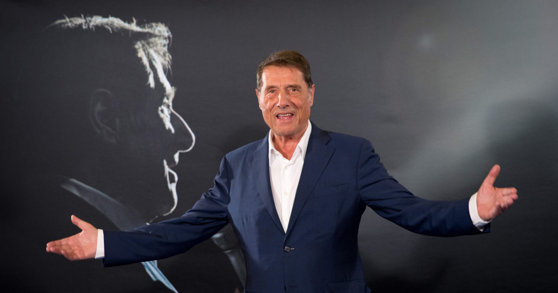 Mann im Anzug breitet seine Arme aus