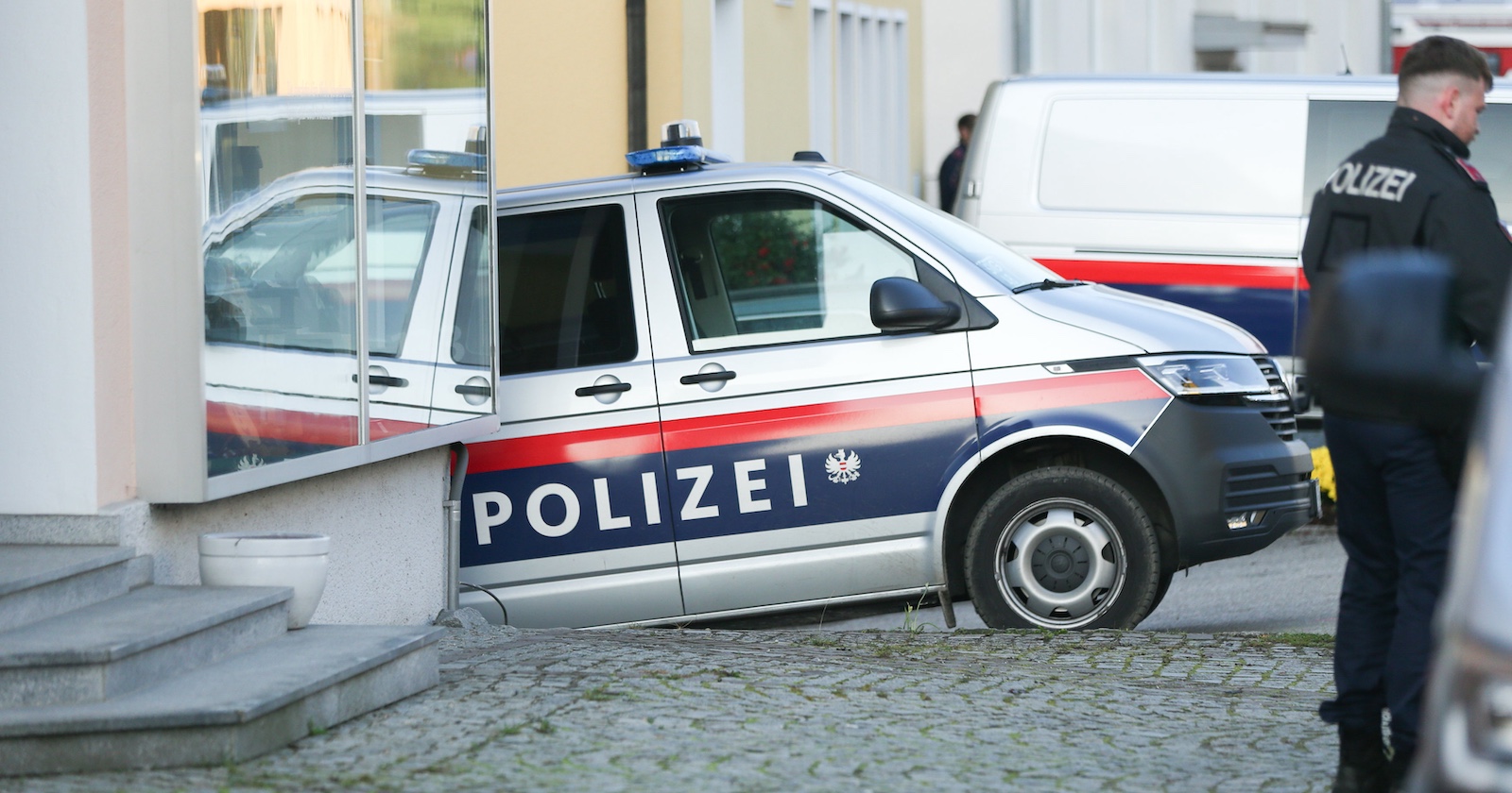 Ein Polizist und eine Polizeiauto.