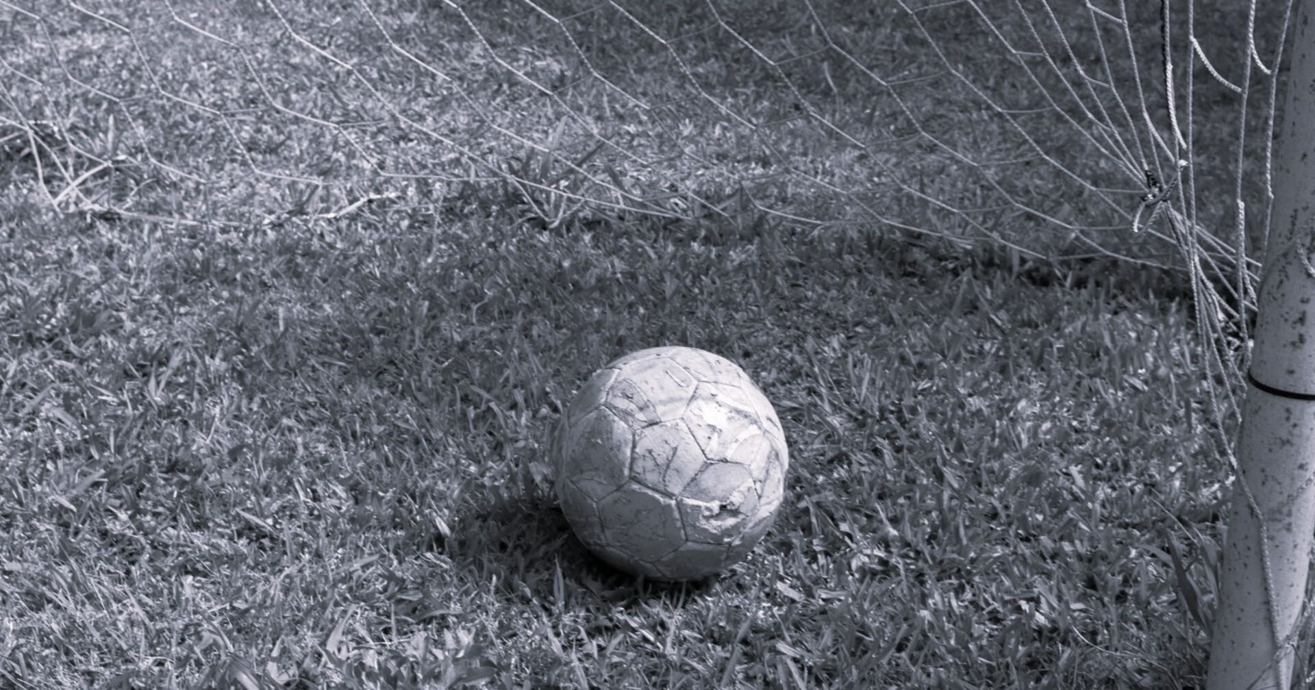 Fußball auf Platz im Tor liegend