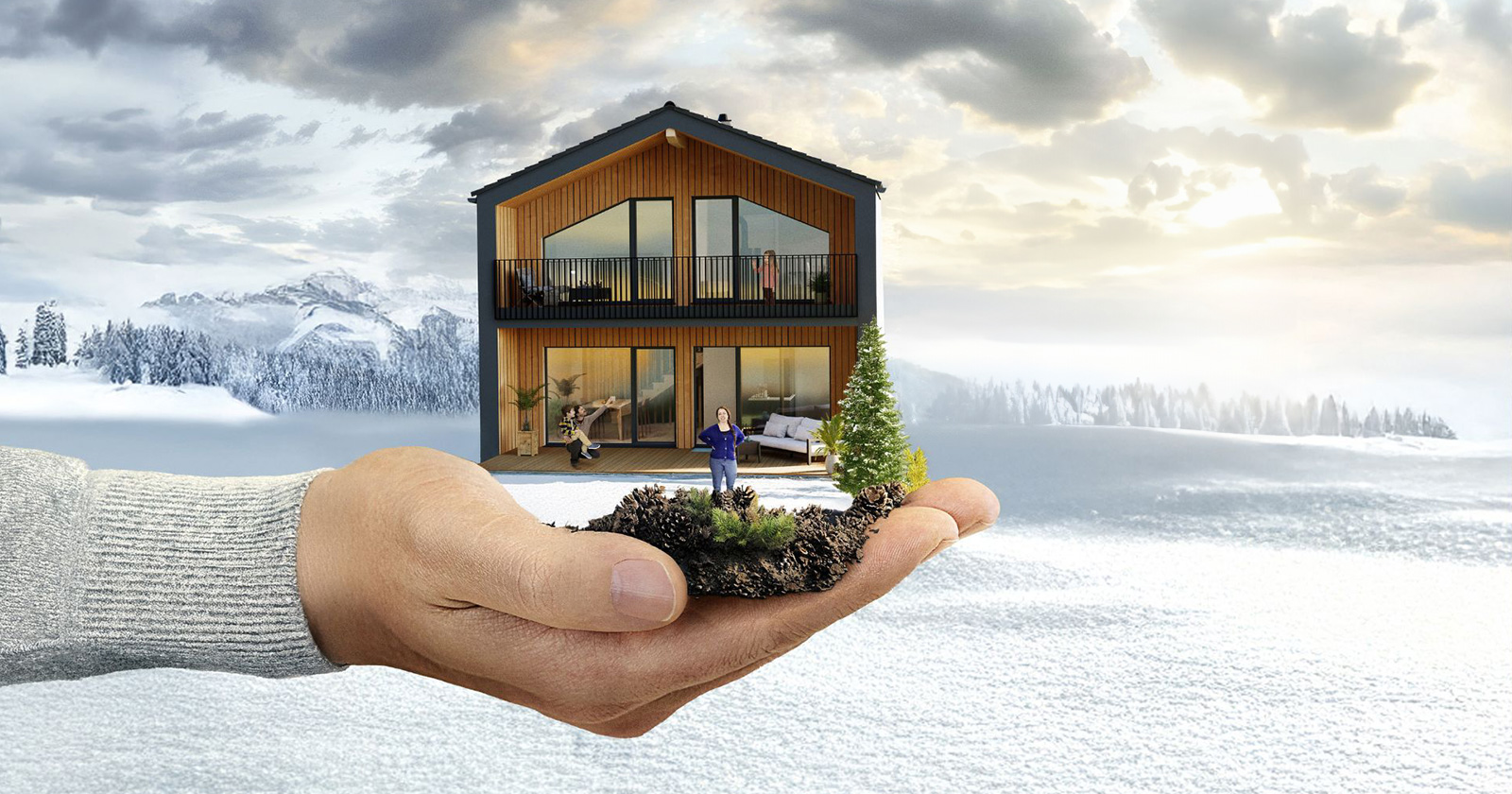 Miniaturhaus in der Hand eines Mannes vor winterlicher Kulisse | Credit: HARTL HAUS