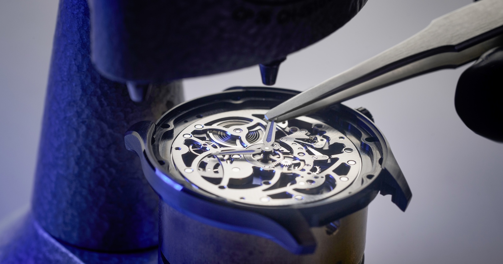 Ein Uhrmacherwerkzeug bearbeitet ein Zifferblatt