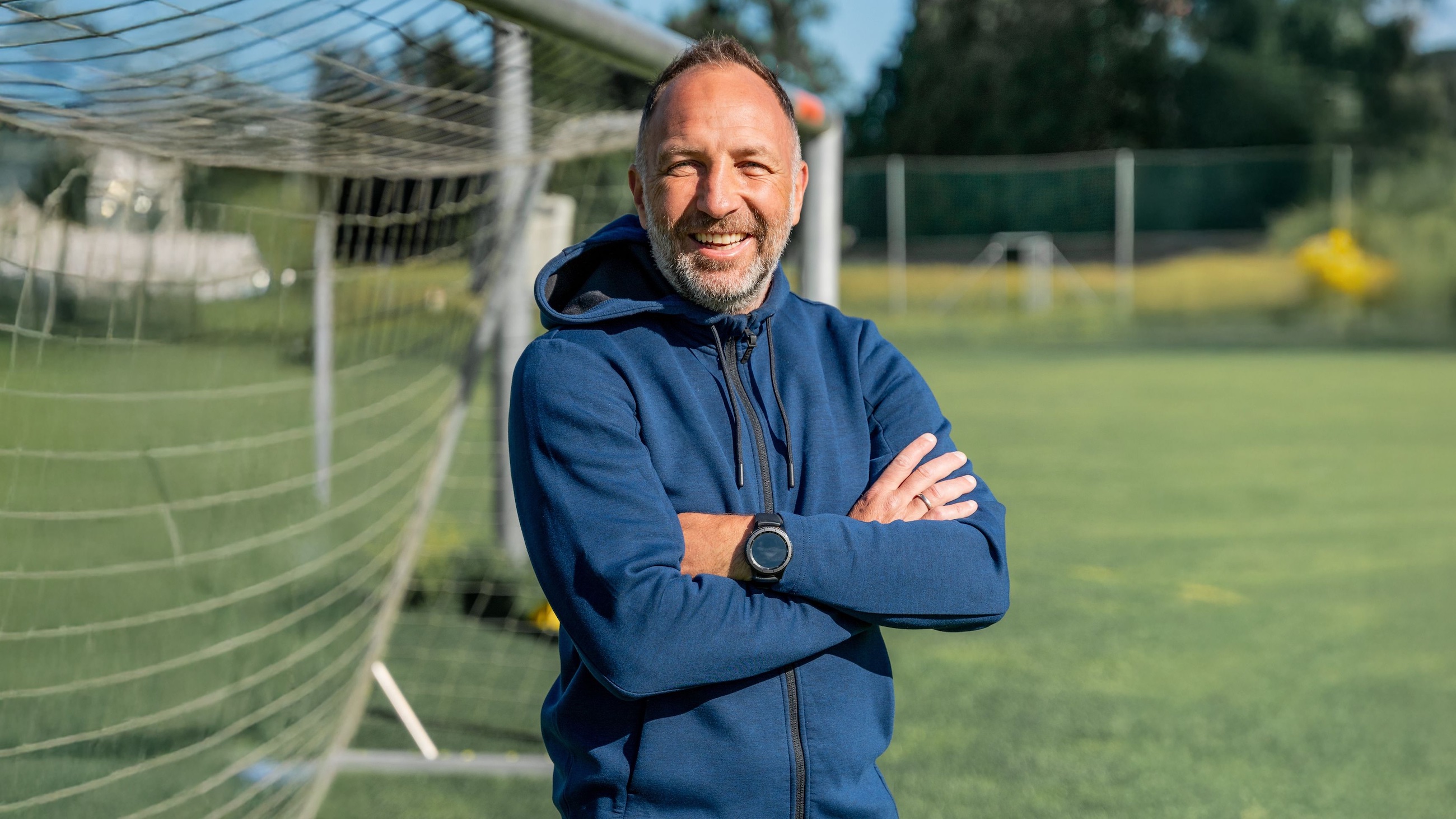 Alexander Schriebl verschränkt die Arme vor sich und grinst