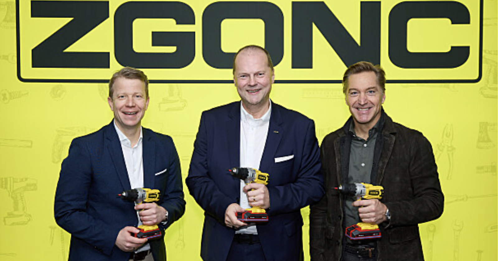 Drei Männer vor großem Zgonc Banner mit Akuuschraubern