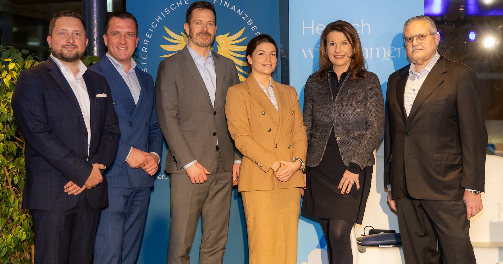 Führungskräfte vor einer Werbeplakatwand beim C-Level-Treffen im Saturn Tower