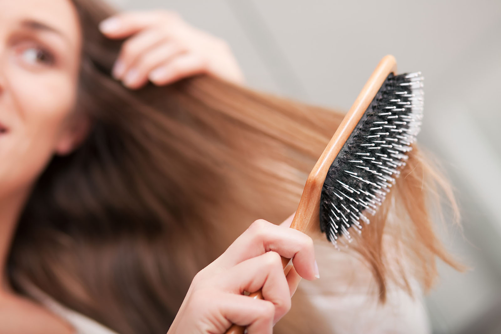 Frau bürstet sich die Haare | Credit: iStock.com/kzenon