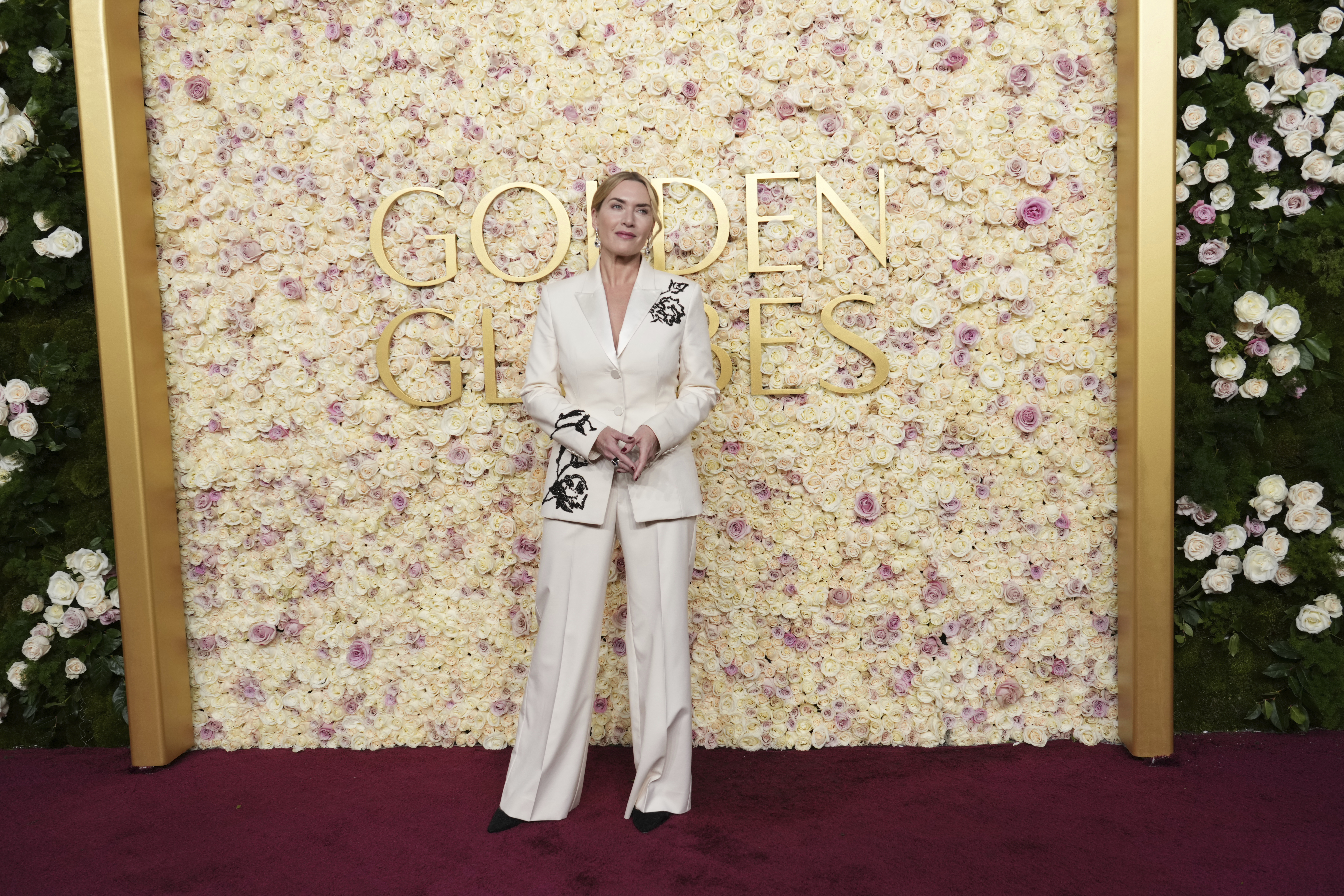 Blonde Frau in einem weißen Anzug am Roten Teppich