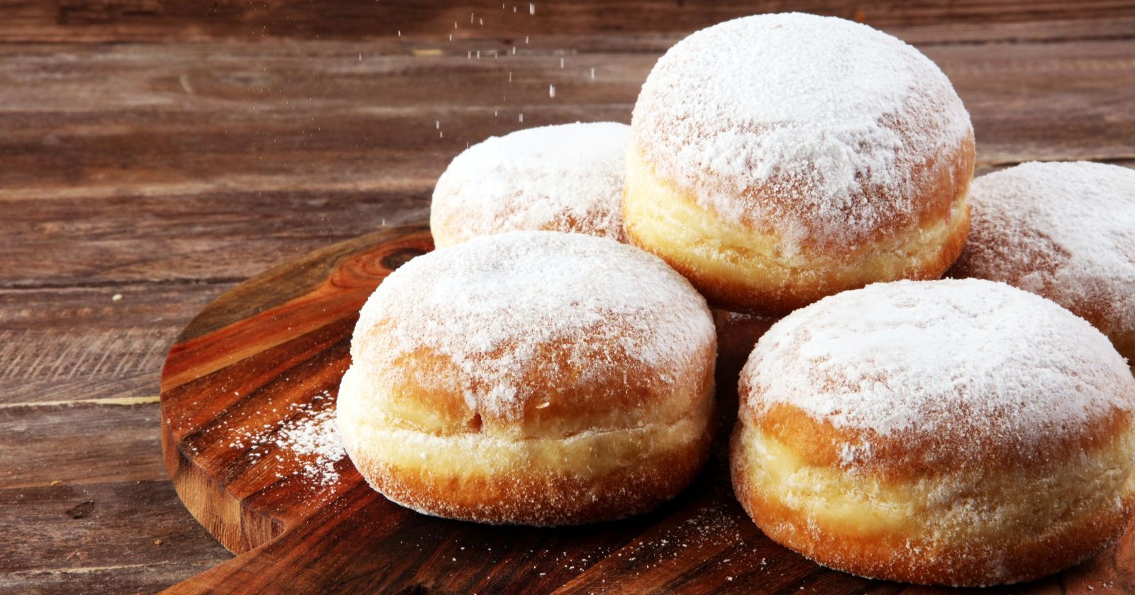 Fünf Krapfen auf einem Holzbrett