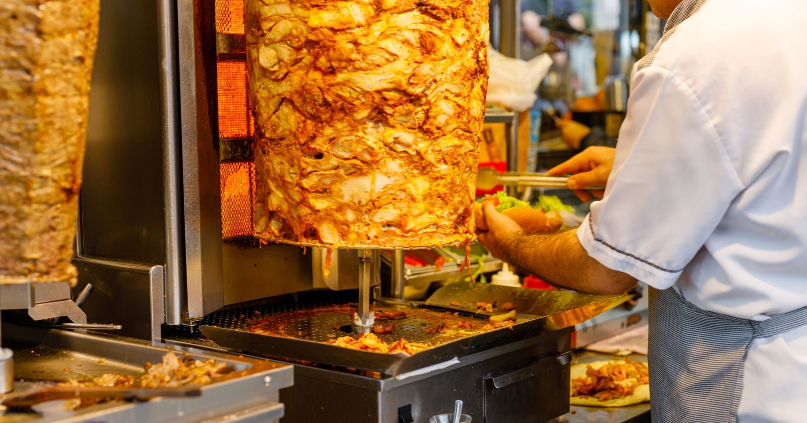 Dönermann schneidet Fleisch