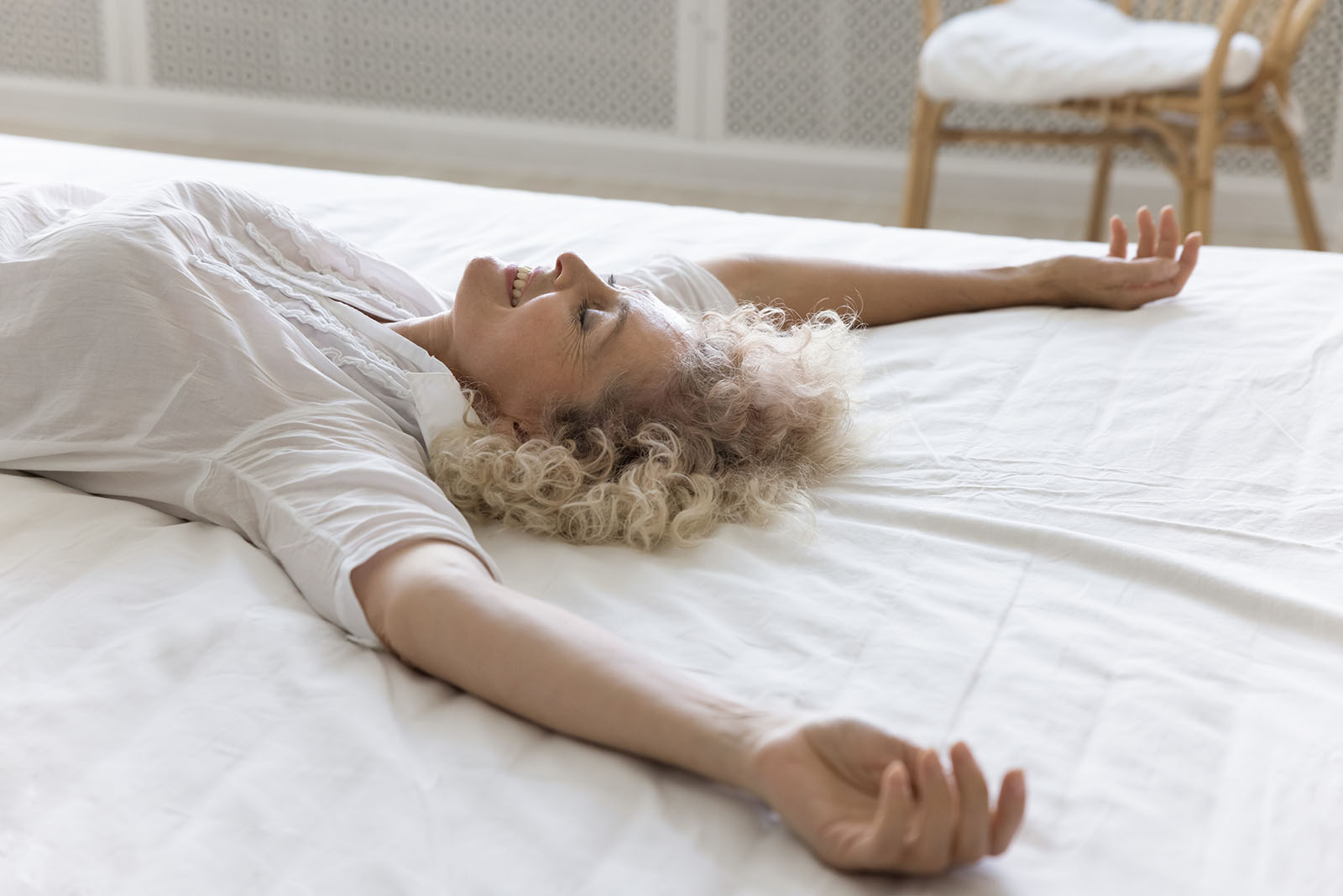 Frau liegt im Bett | Credit: iStock.com/fizkes