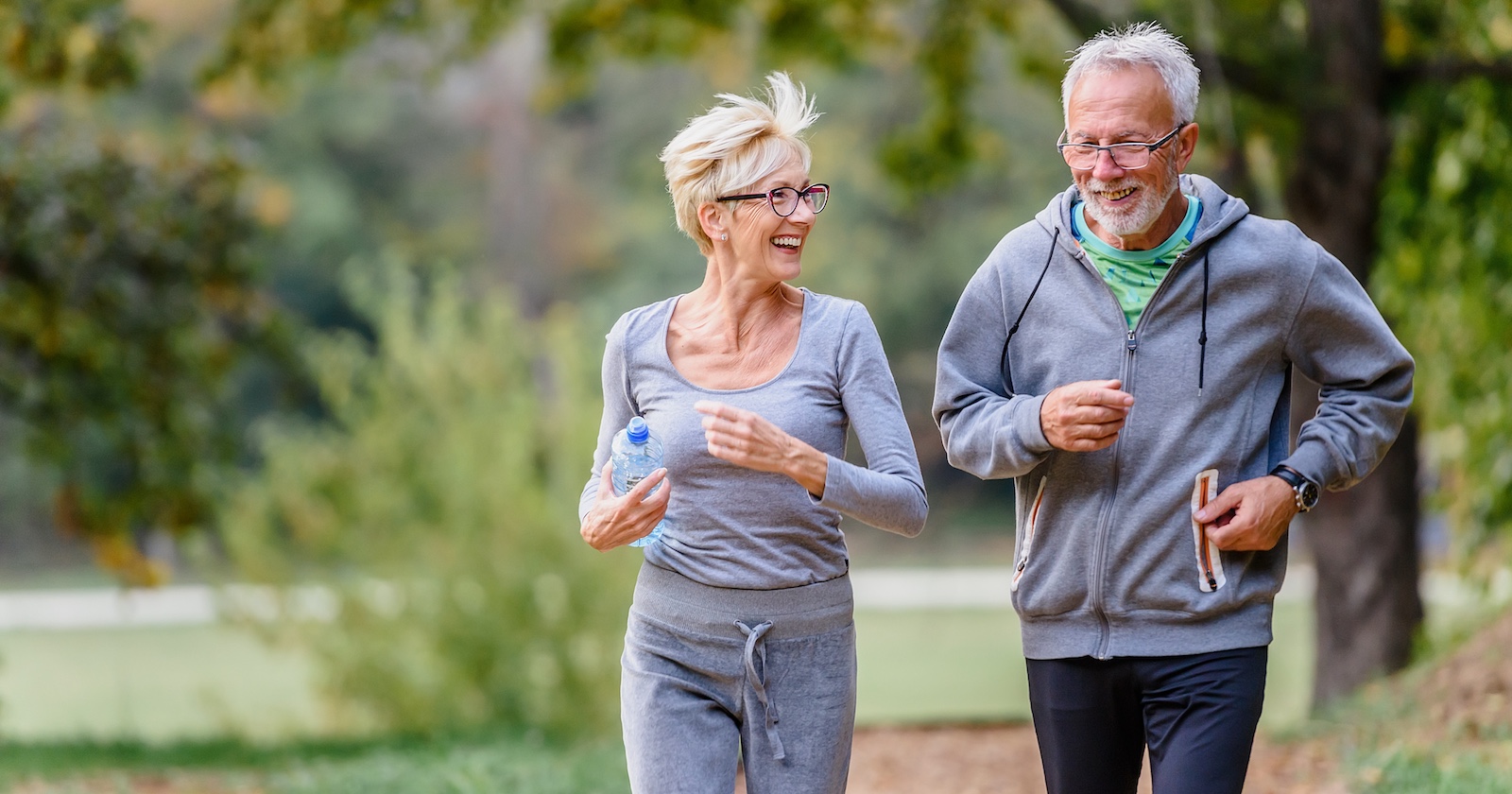 Moderate Bewegung wie beim Nordic Walking oder zügigen Spazierengehen tut der Psyche und dem Körper gut: Ein Mann und eine Frau genießen die gemeinsame Bewegung im Freien.