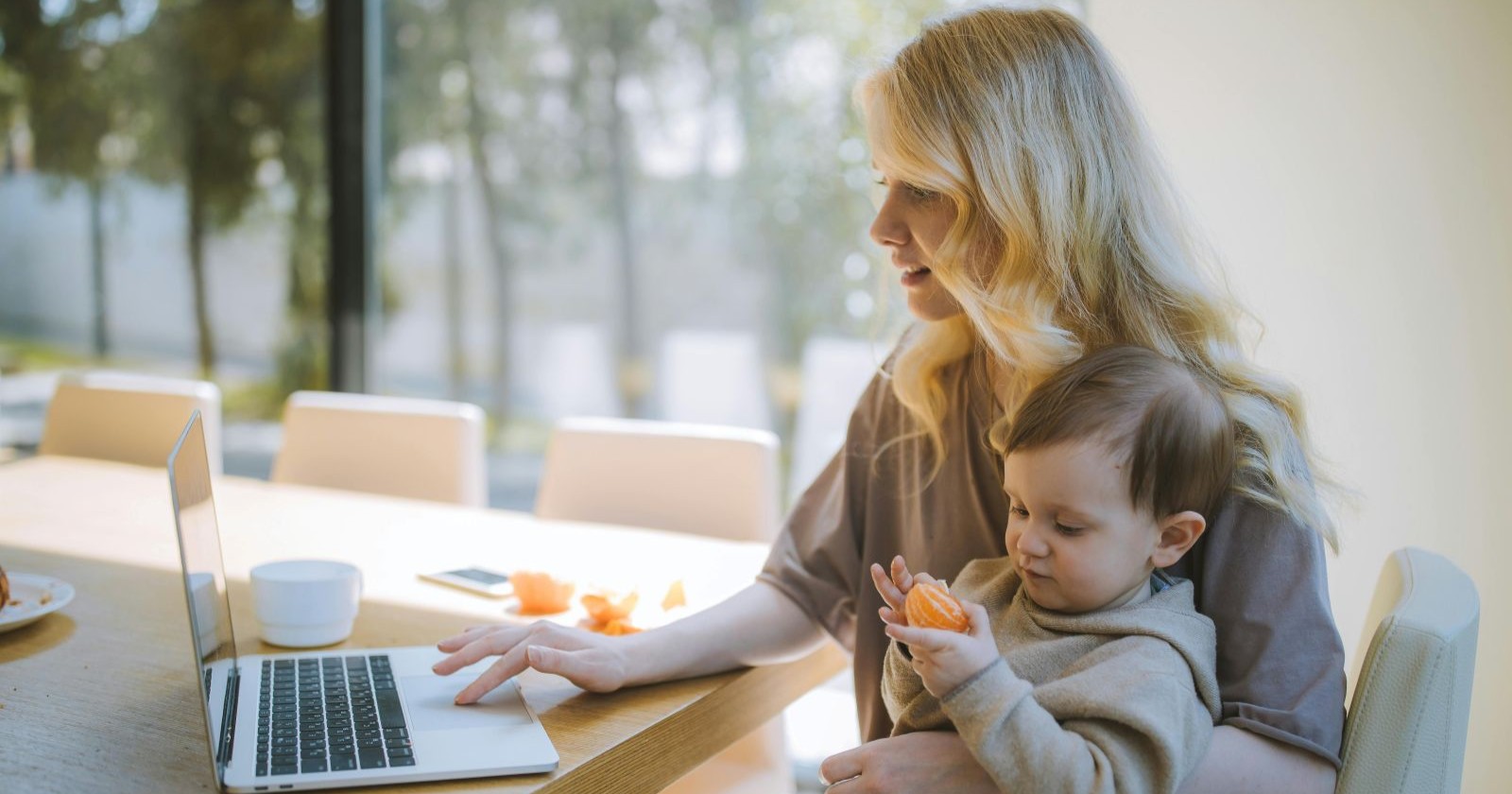 Frau mit Baby und Laptop