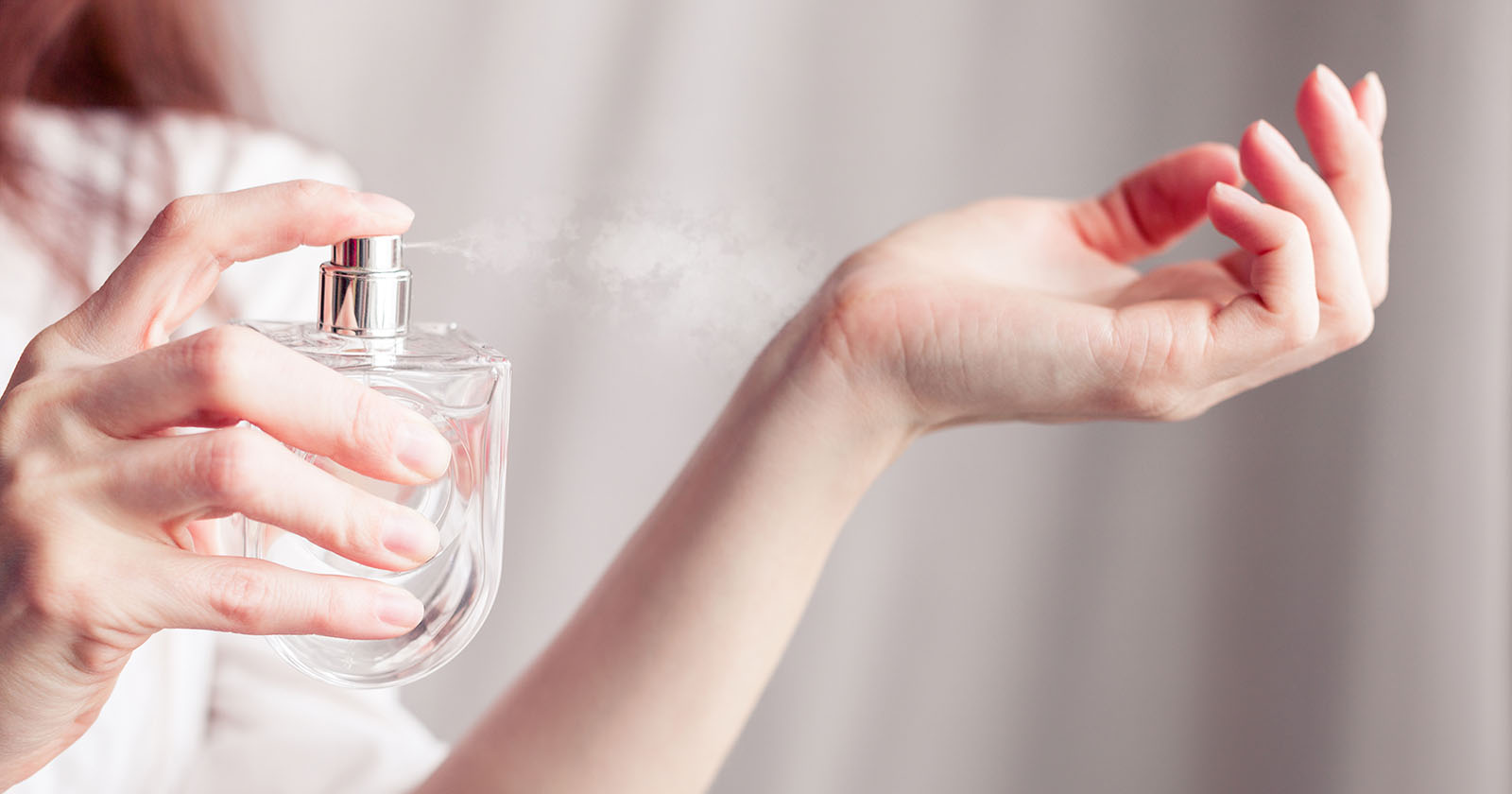 Frau sprüht Parfum auf ihre Hand | Credit: iStock.com/Angelika-Angelika