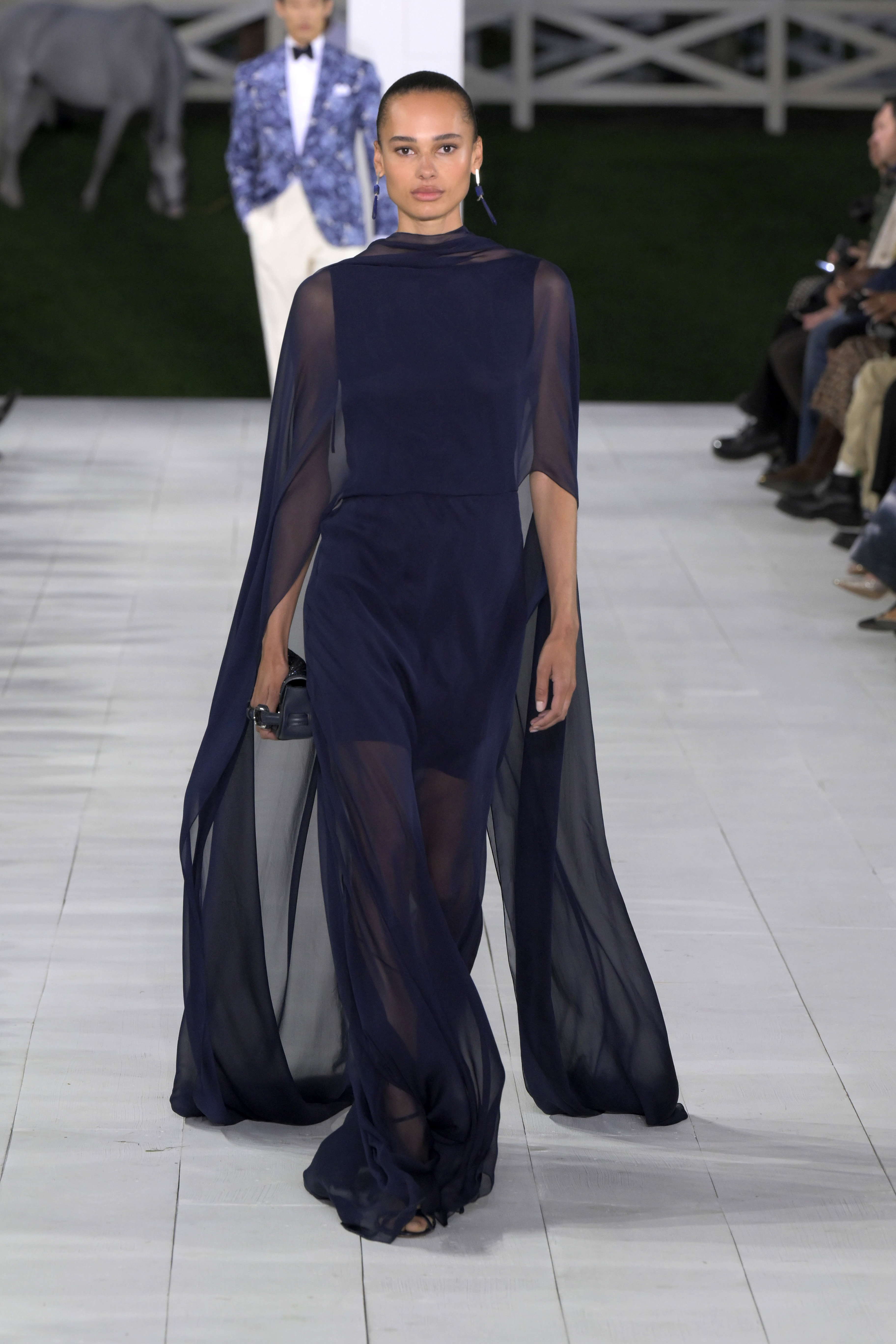 Model in einem dunkelblauen Kleid am Laufsteg